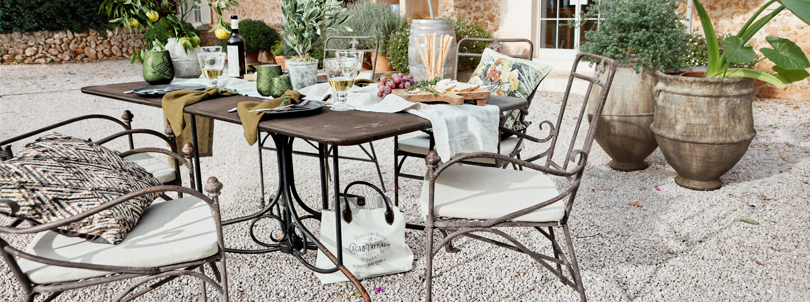 Tuinset met metalen stoelen en mediterrane decoratie op grindterras buiten