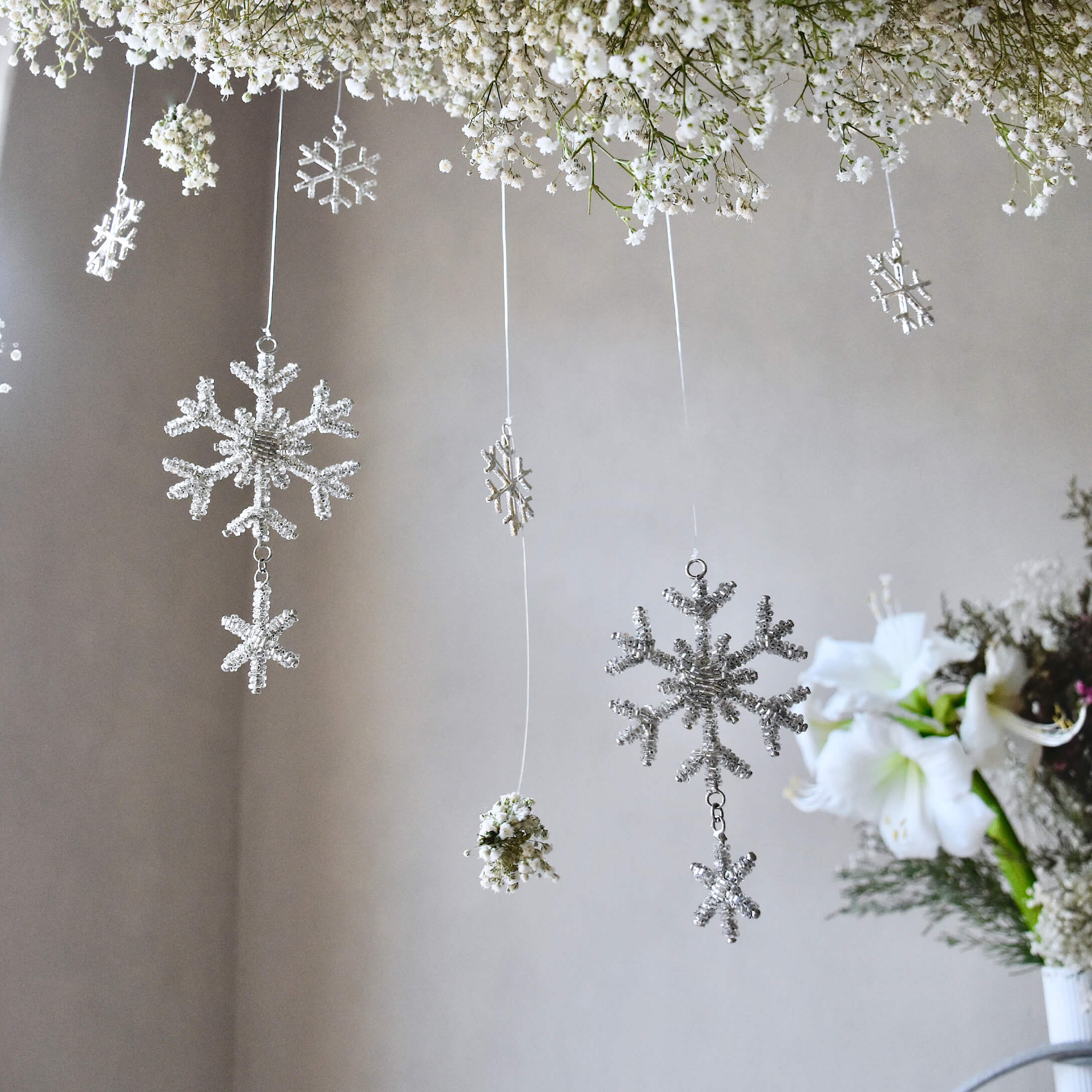 Witte sneeuwvlok- en bloemenhangers aan draad, subtiele winterse interieurdecoratie