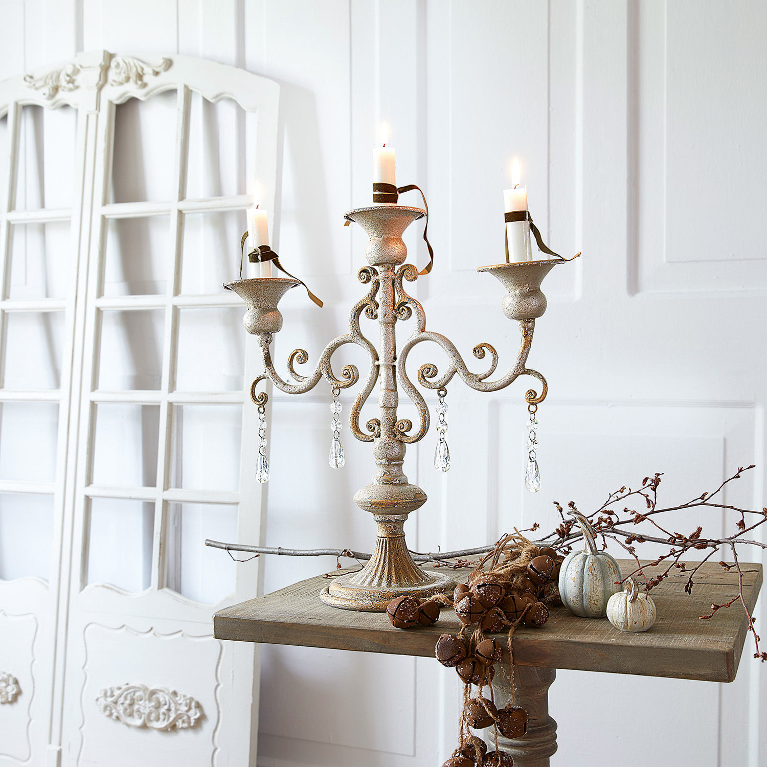Kaarsenstandaard Chantan Witte metalen vintage kandelaar met drie armen en kristallen hangers op houten tafel