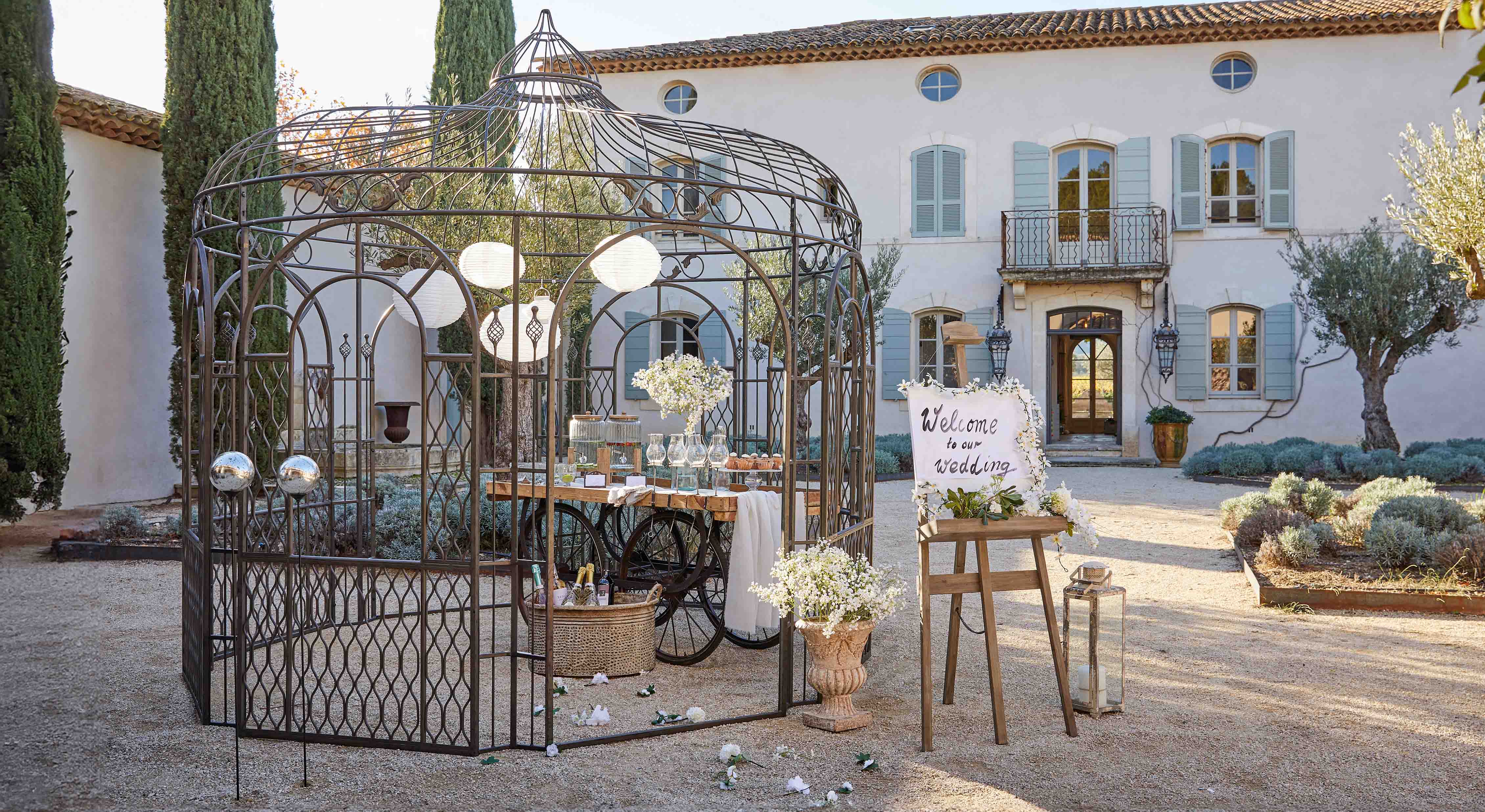 Metalen prieel met decoratief patroon in tuin met tafel en bloemen voor bruiloft