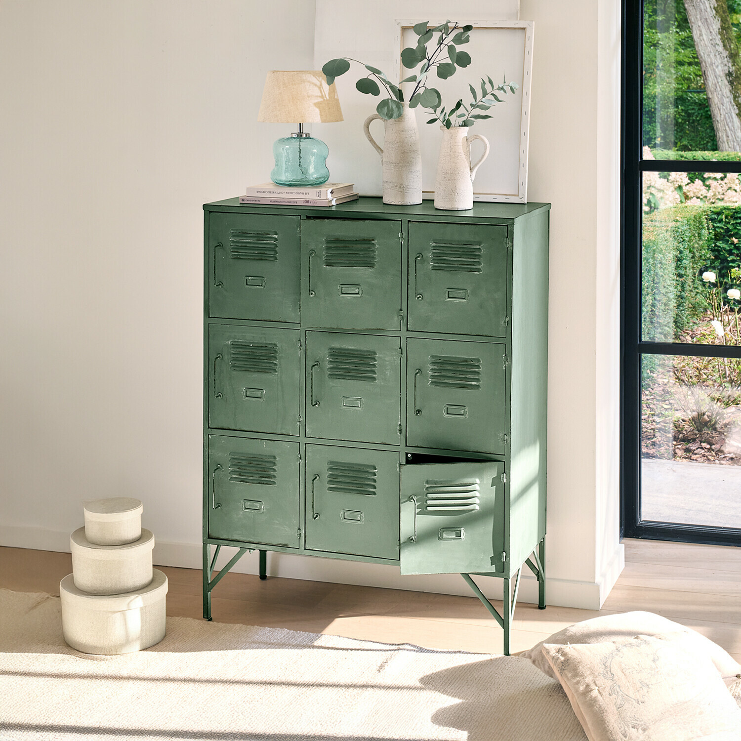 Kastje Urillac Groene metalen kast met negen deuren en decoraties bovenop in lichte kamer