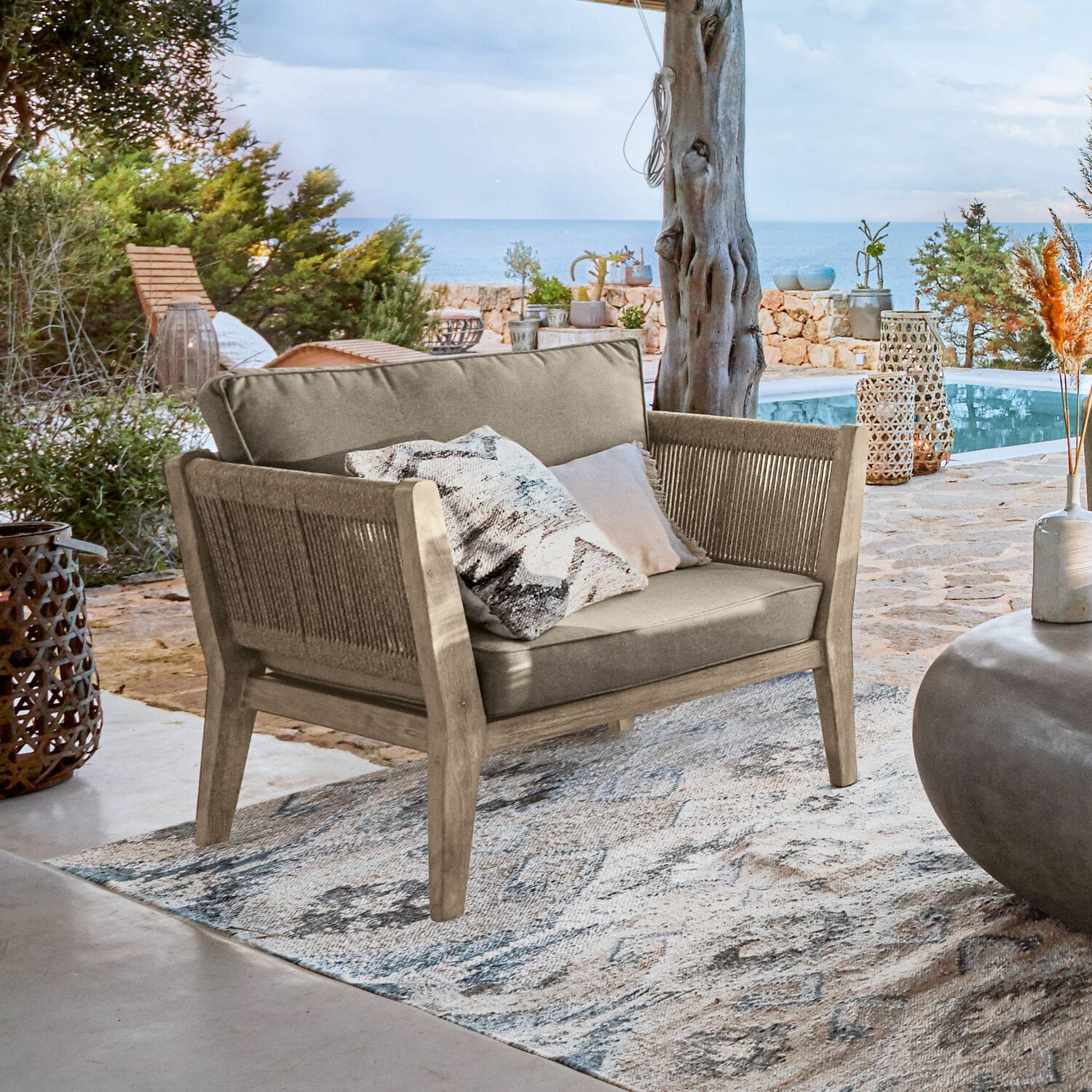 Fauteuil FSC®-100% Biarritz Buitensofa van hout en beige stof op terras met uitzicht op zee