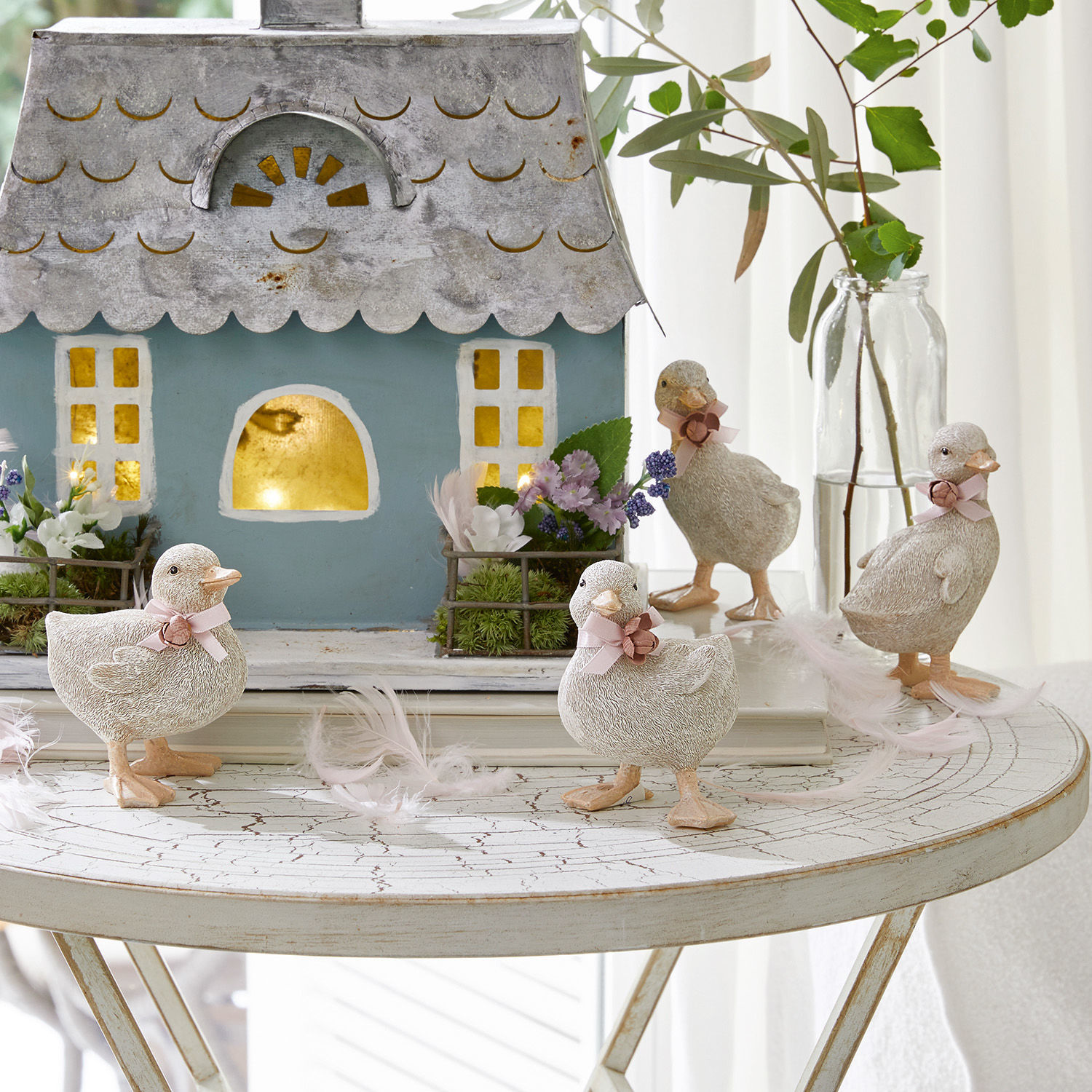 Kuiken set van 4 Orélie Decoratieve eendenfiguren van licht materiaal op witte tafel met huis en bloemen