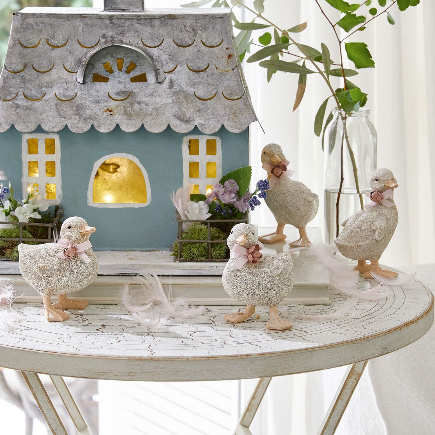 Kuiken set van 4 Orélie Decoratieve eendenfiguren van licht materiaal op witte tafel met huis en bloemen