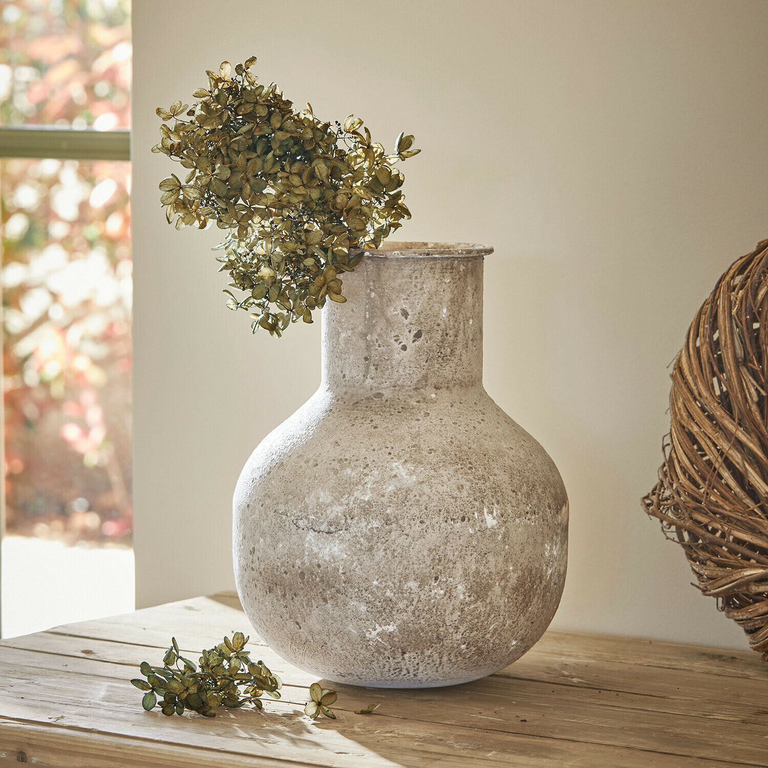 Vaas Delavine Grote grijze keramische vaas met gedroogde bloemen op houten tafel in lichte kamer
