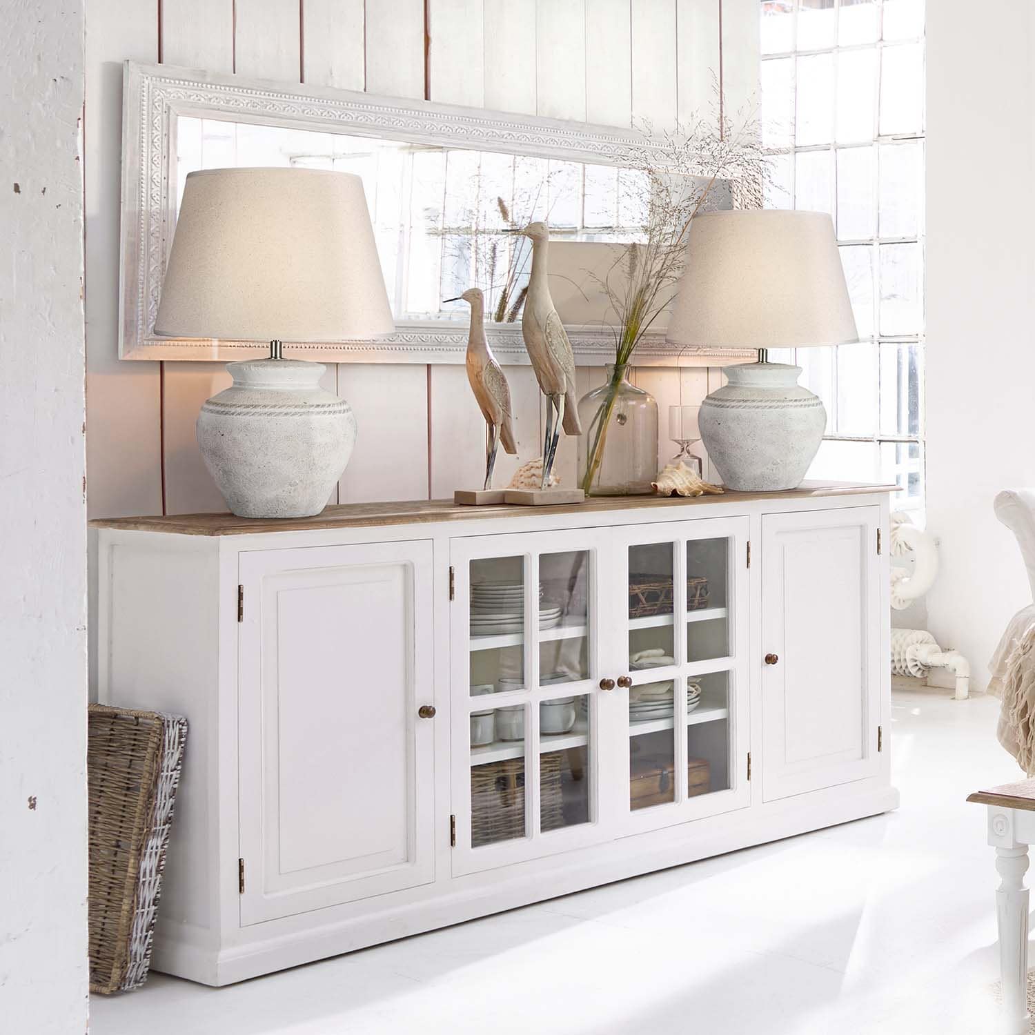Witte houten dressoir met glazen deuren en keramische lampen in lichte kamer