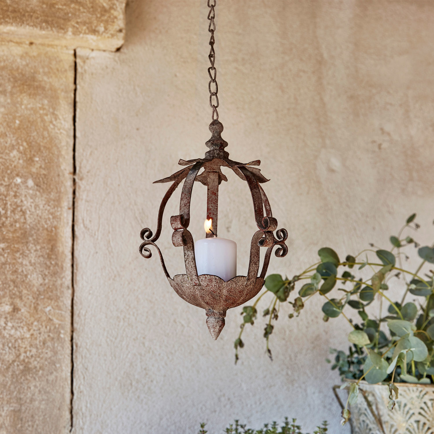 Hangende kandelaar van roestig metaal met witte kaars, decoratie voor binnen en tuin