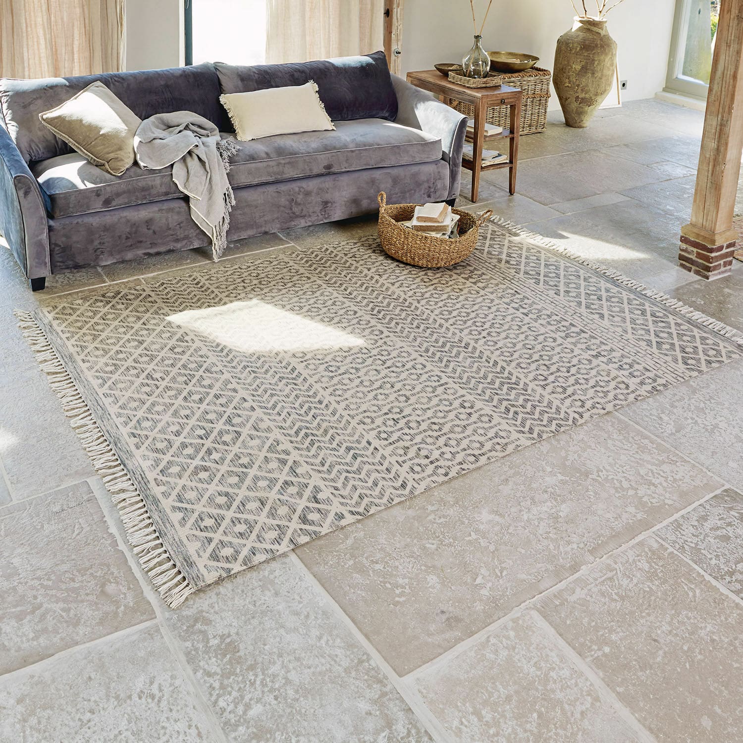 Vloerkleed voor binnen en buiten Champigny Beige vloerkleed met geometrisch patroon en franjes op stenen vloer in lichte woonkamer