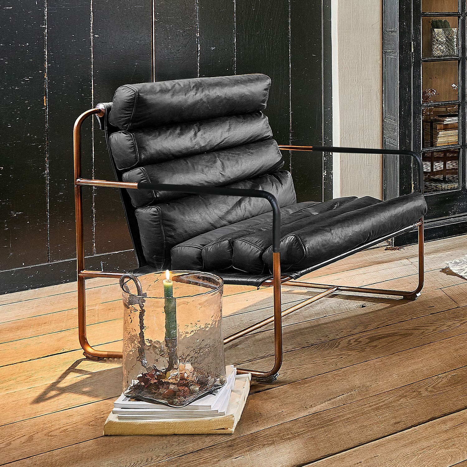 Fauteuil Jelvano Zwarte leren fauteuil met koperen frame op houten vloer in moderne kamer