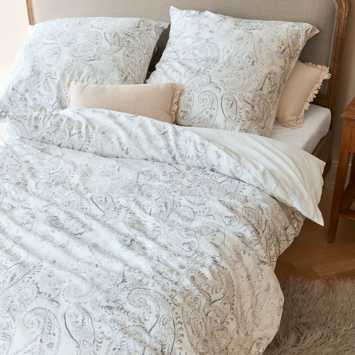 Beddengoed Caselia Katoenen beddengoed met lichte paisleyprint op bed met beige sierkussens