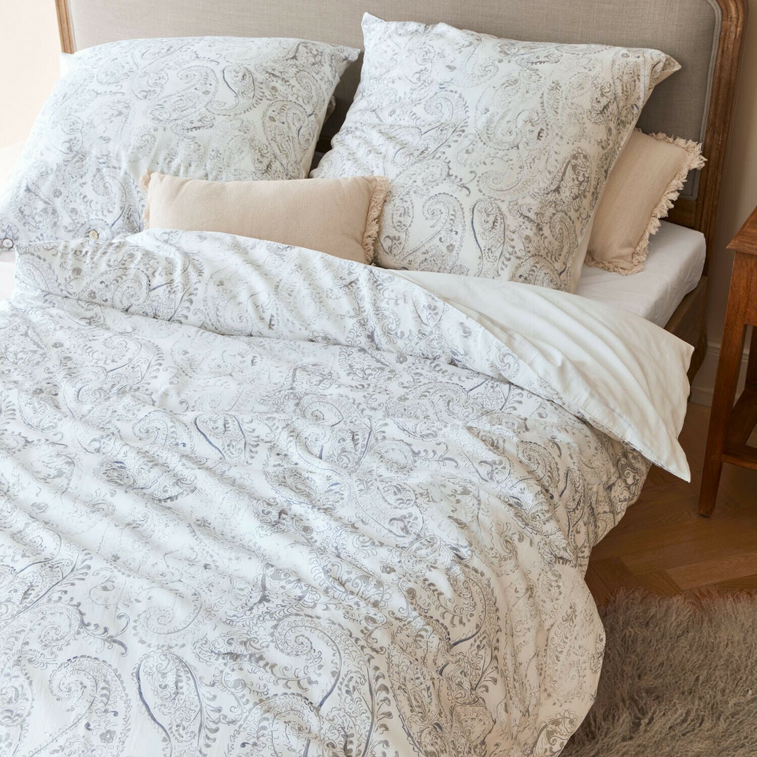Beddengoed Caselia Katoenen beddengoed met lichte paisleyprint op bed met beige sierkussens
