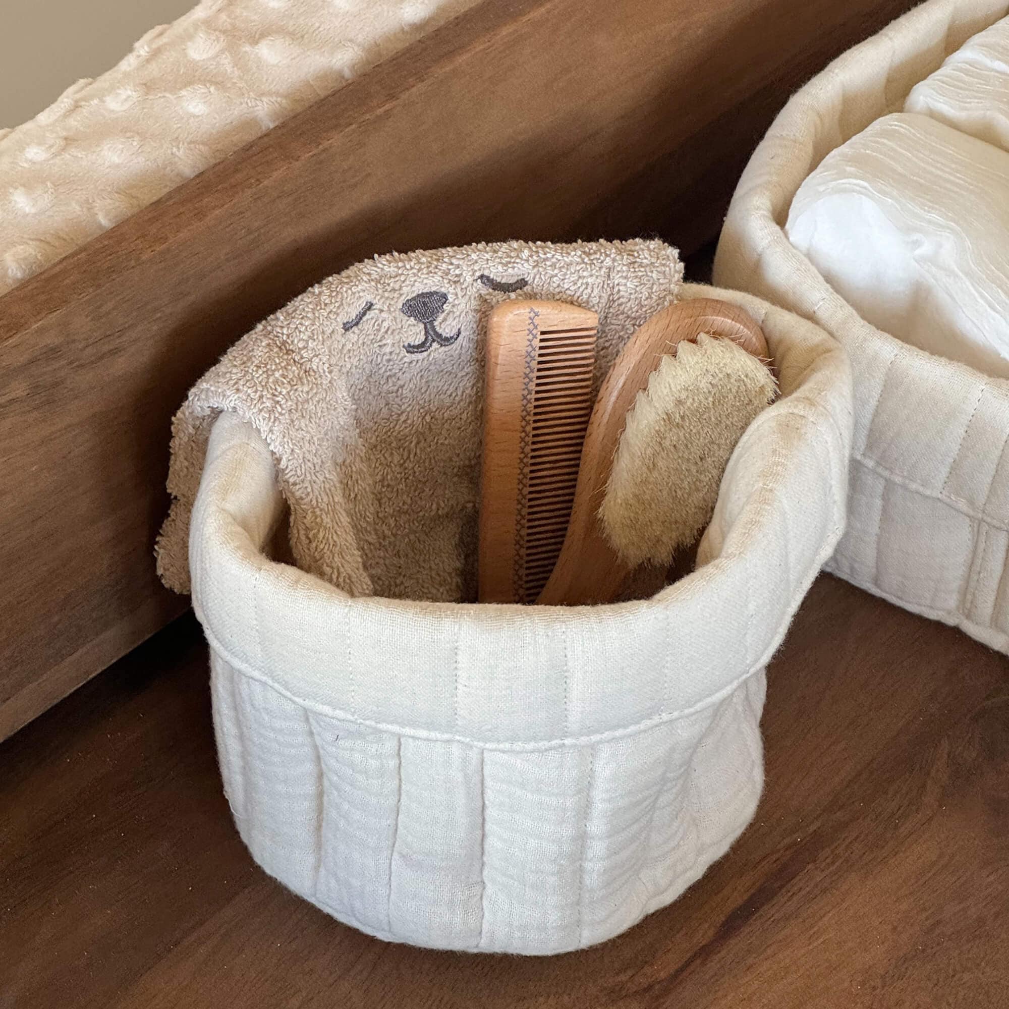 Crèmekleurige katoenen mand met zachte handdoek en houten borstel, natuurlijke badkameraccessoires