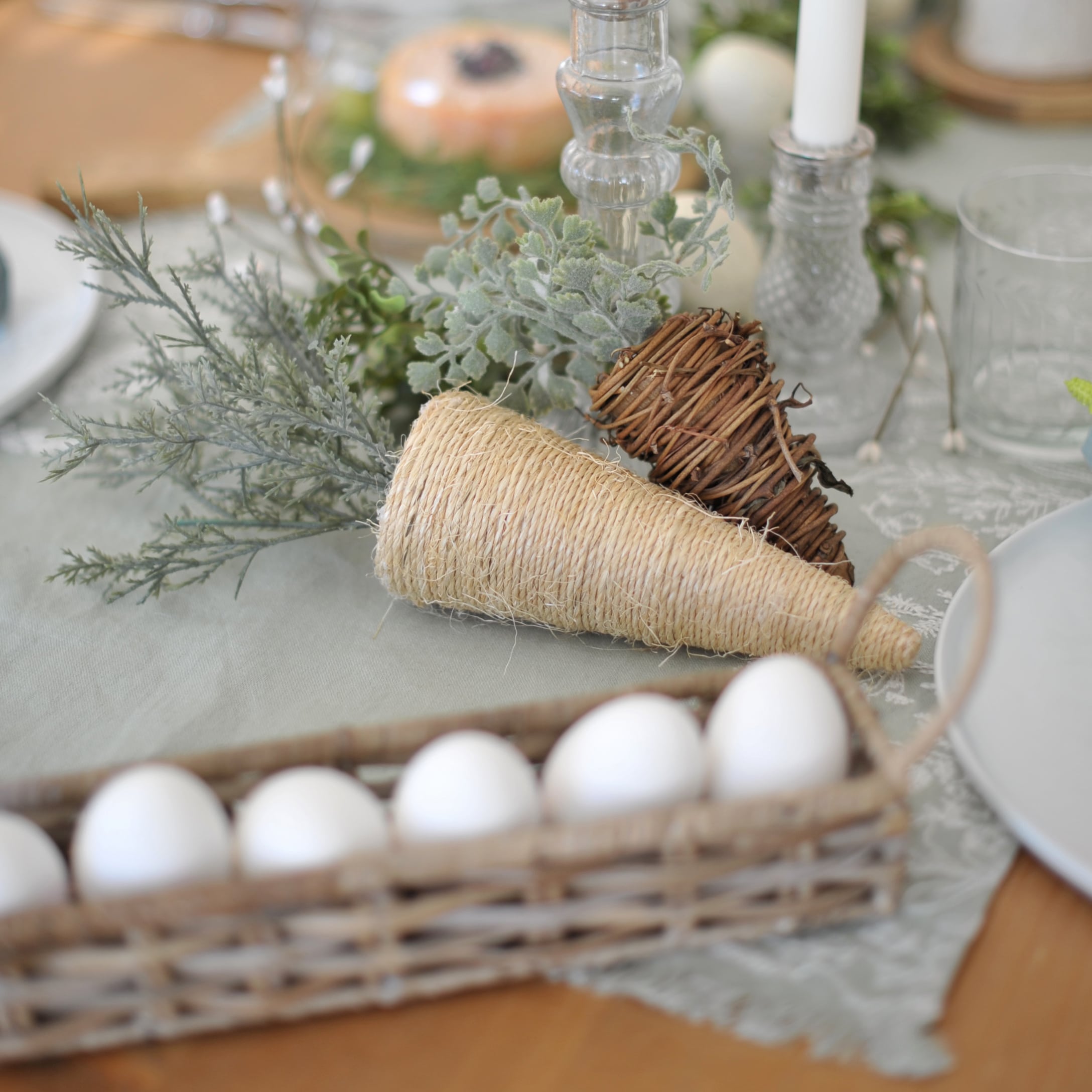 Decoratieve kegels van natuurlijke materialen met groene takken op feestelijke tafel