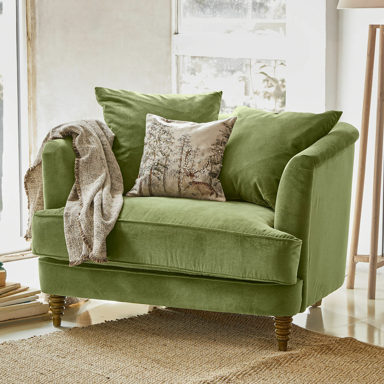 Fauteuil Etueffont Groene fluwelen bank met kussens en beige deken op natuurlijke vloerkleed in lichte kamer