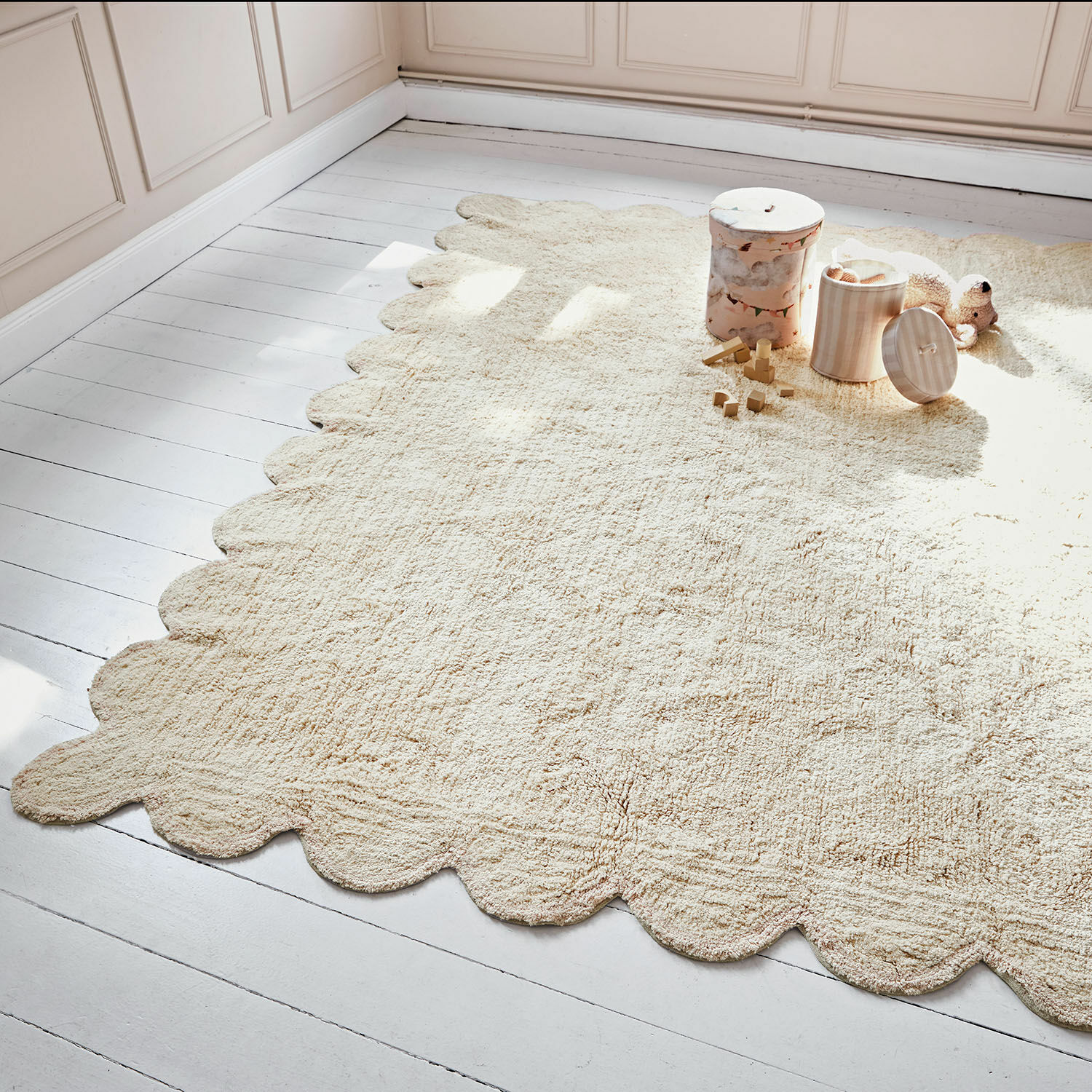 Beige vloerkleed van zacht materiaal met golvende randen op lichte vloer, stijlvolle woondecoratie