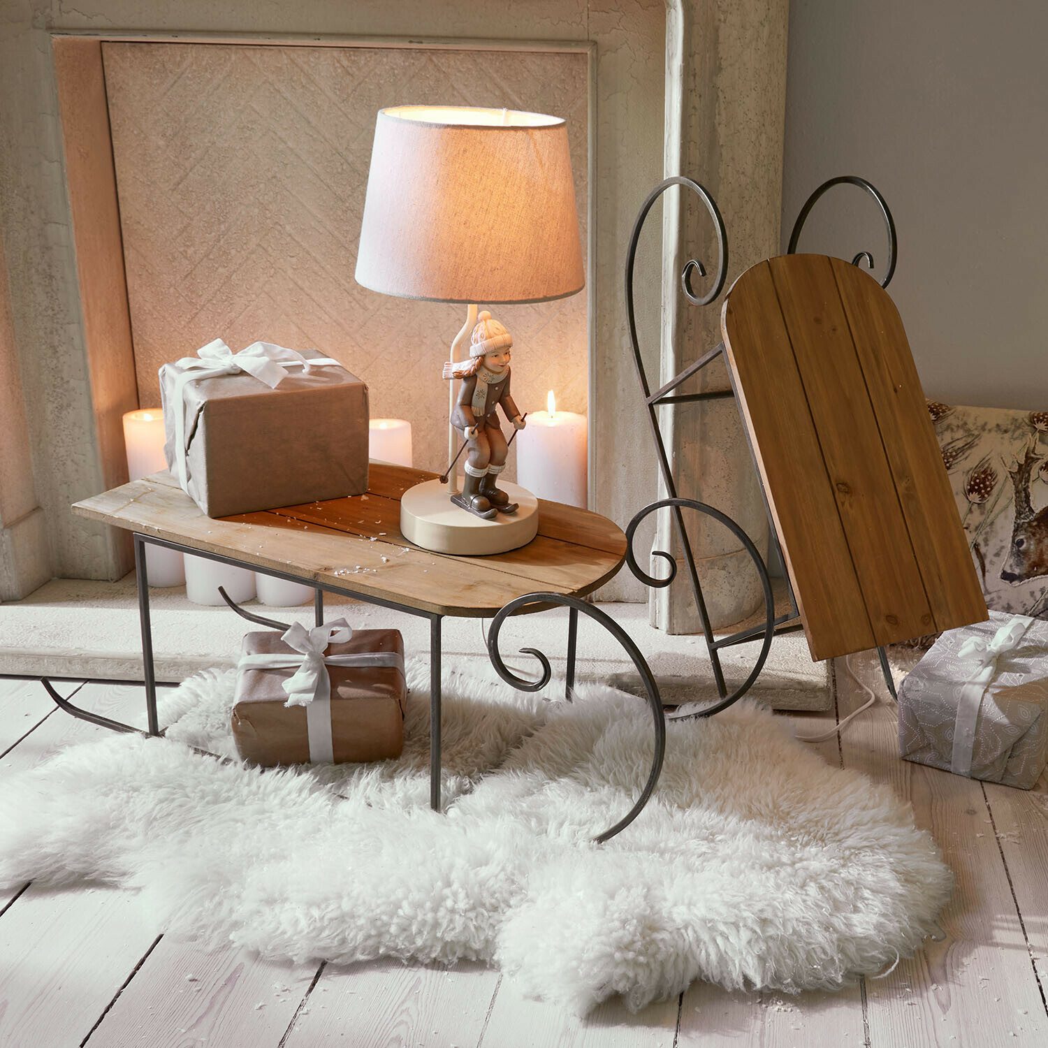Bijzettafel in slee-vorm van hout en metaal met lamp en cadeaus op witte schapenvacht