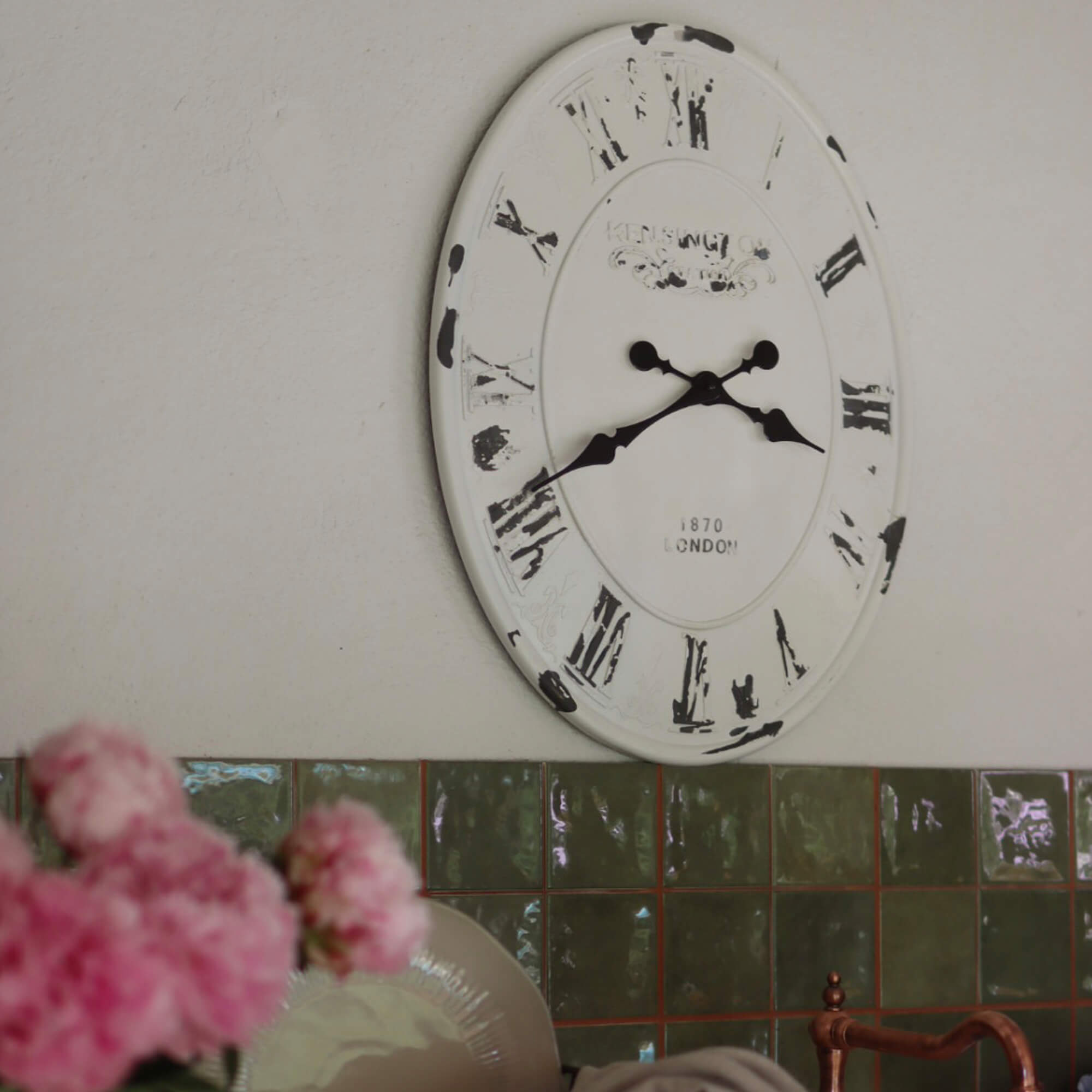 Witte metalen wandklok met zwarte Romeinse cijfers en verouderde look voor interieurdecoratie