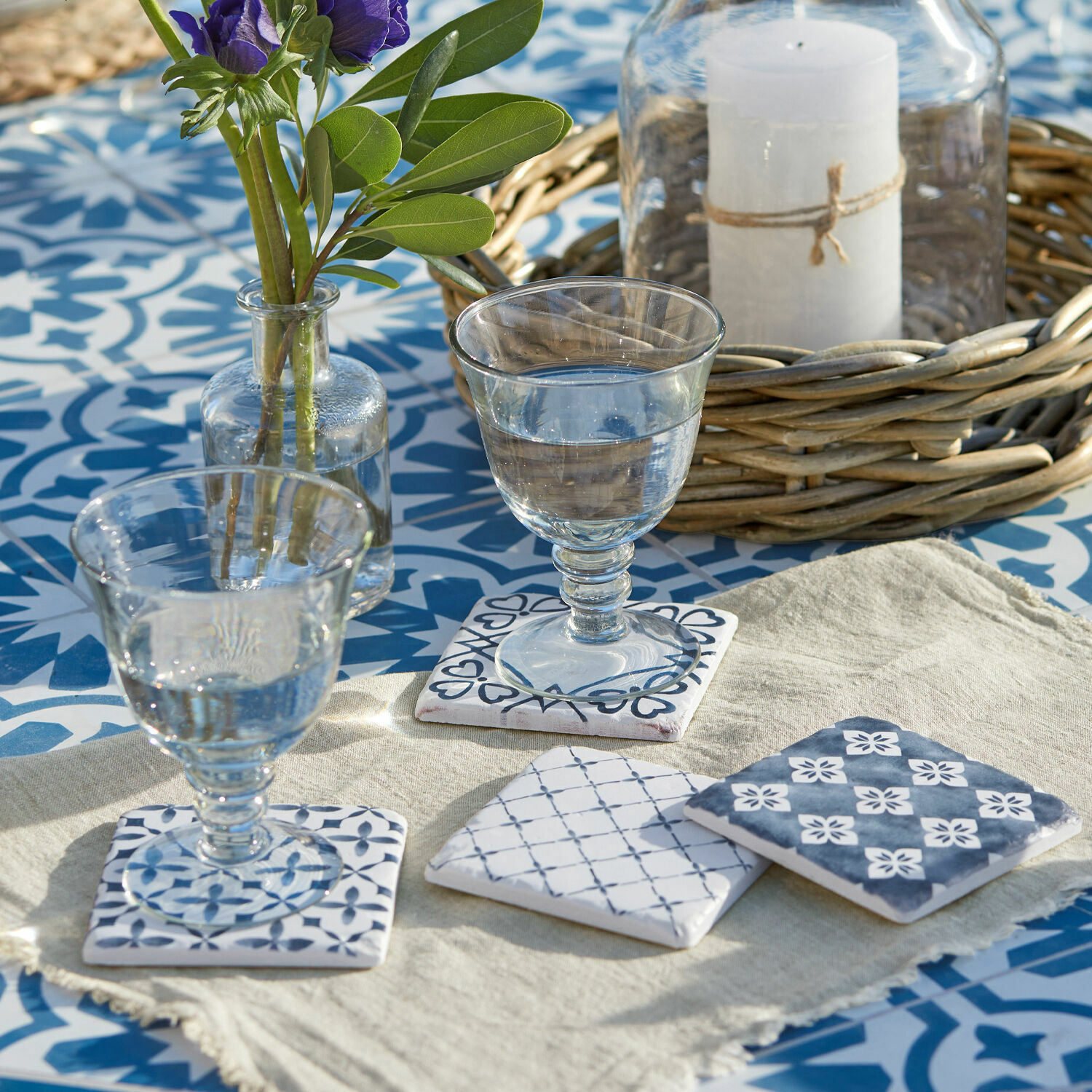 Onderzetter set van 4 Sliwa Keramische onderzetters met blauw patroon op lichte achtergrond op tafel met blauwe tegels