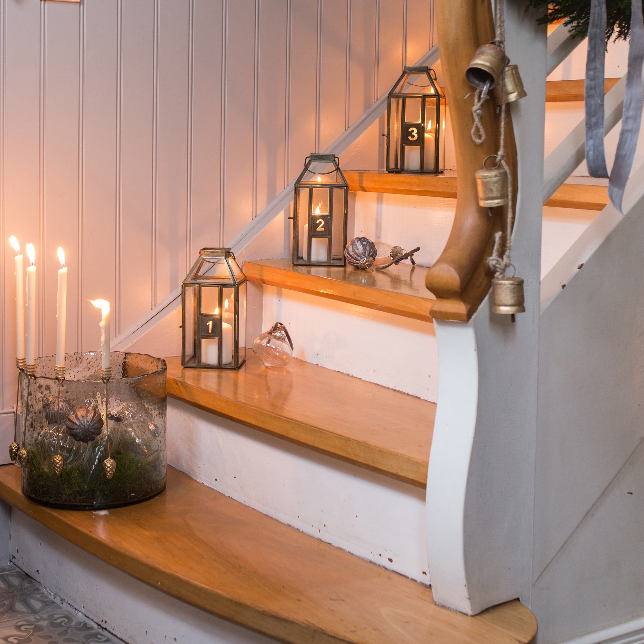 Houten trap met genummerde metalen lantaarns en brandende kaarsen voor warme interieurdecoratie