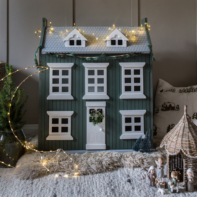 Groen houten decoratief huis met witte ramen en lichtsnoer, kerstversiering voor binnen