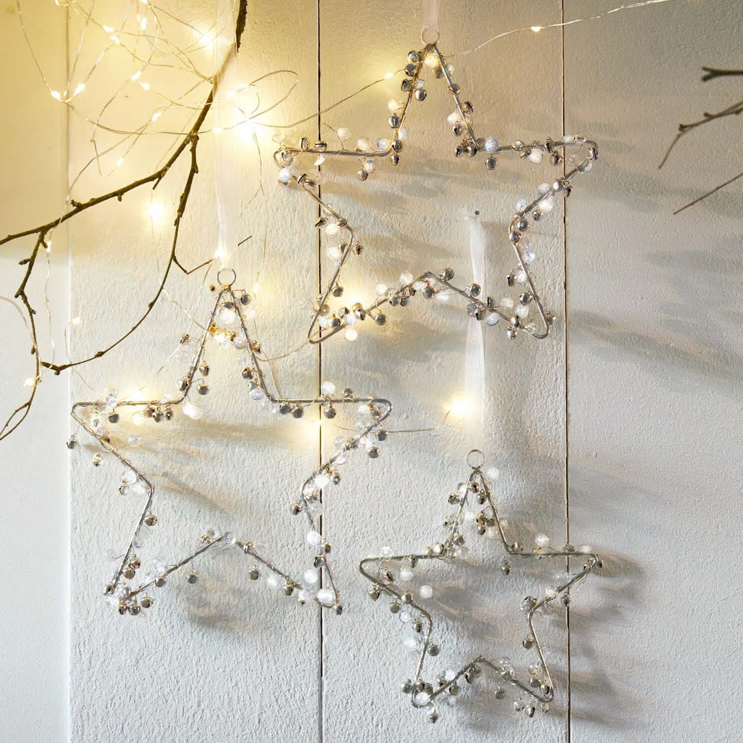 Decoratieve metalen sterren met belletjes en LED-lichtjes voor feestelijke binnenhuisdecoratie