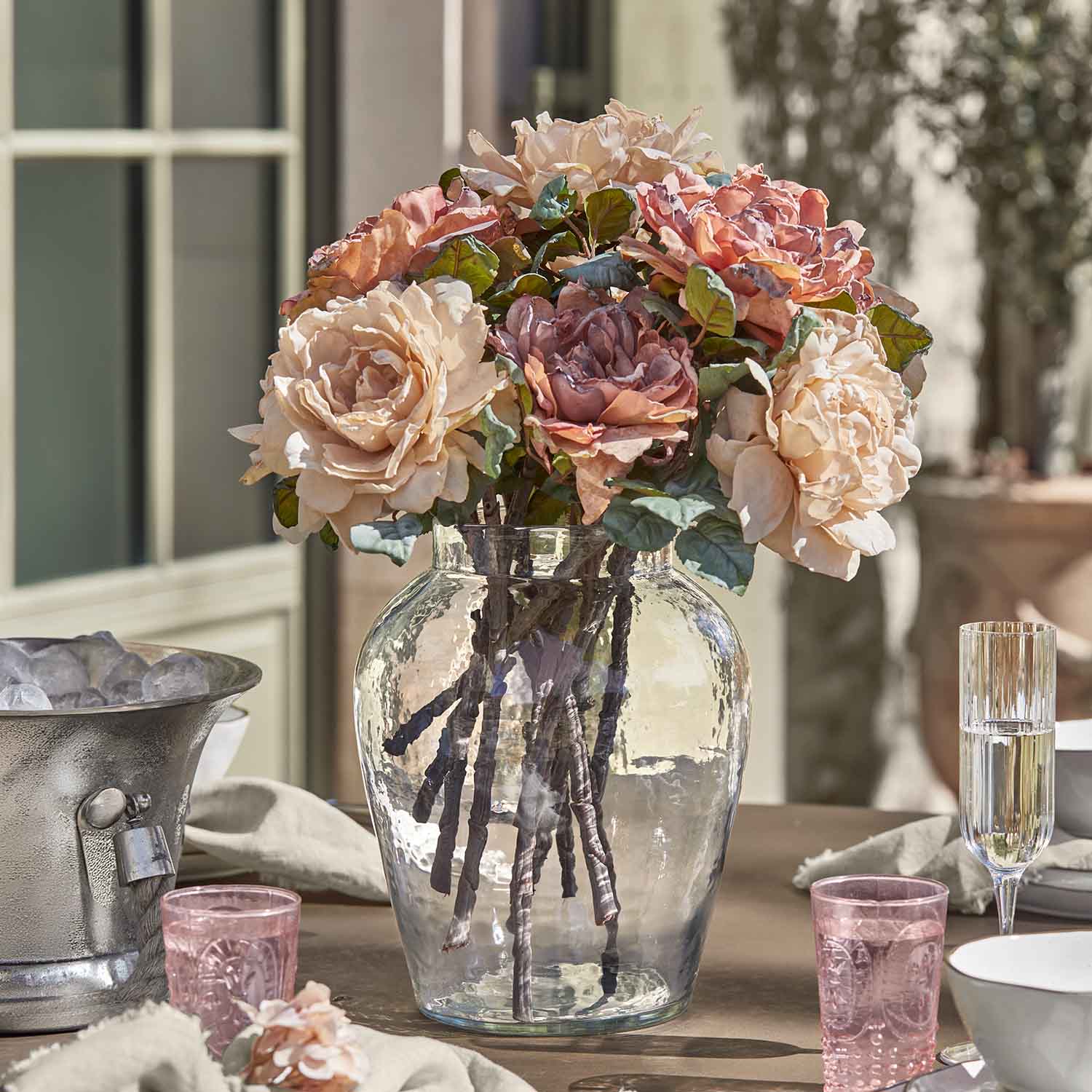 Boeket rozen in glazen vaas op tafel, pastelkleurige bloemendecoratie voor interieur