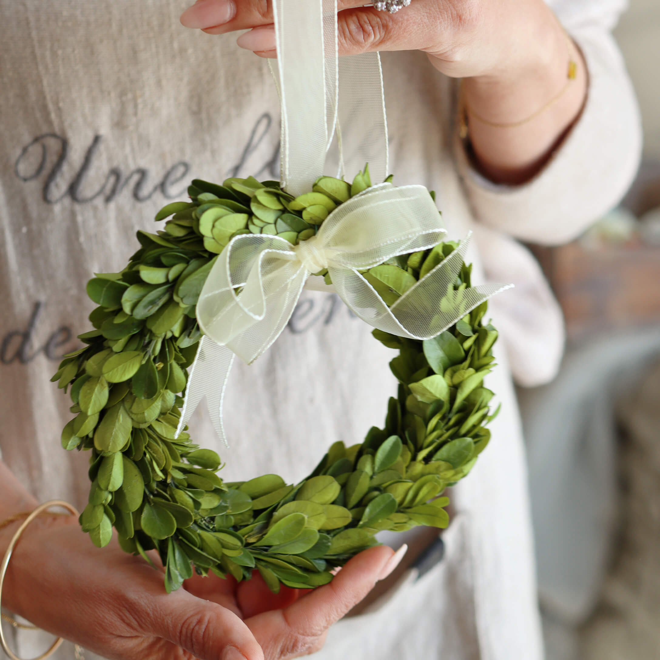 Kleine groene krans van bladeren met witte strik, decoratie voor huis of deur