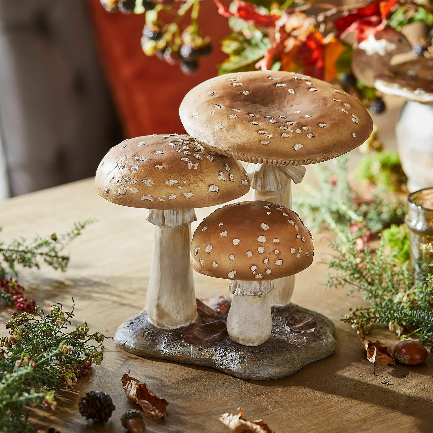 Decoratie van drie bruine paddenstoelen met witte vlekken op voet, herfsttafelversiering