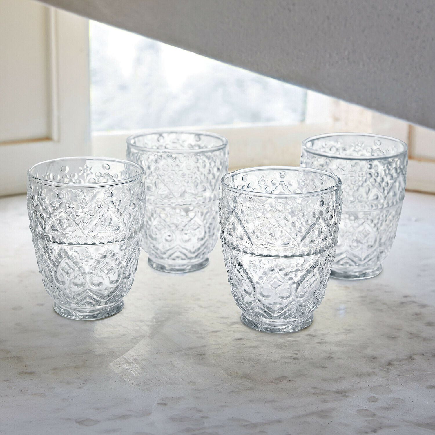 Glazen met rode wijn en fles op witte tafel met decoratieve metalen lampen buiten