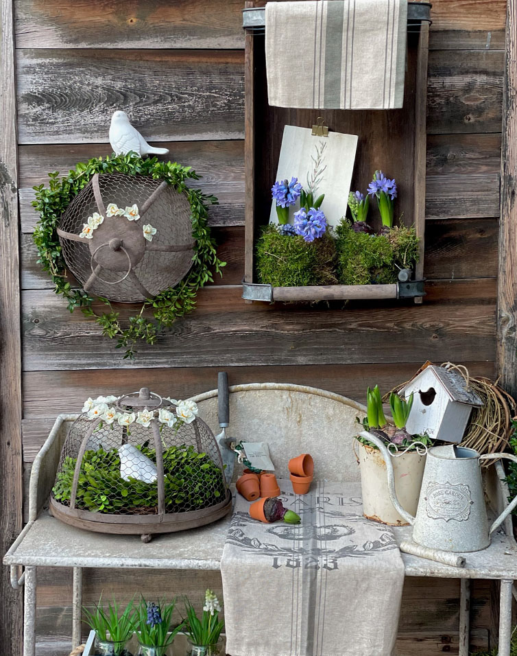 Rustieke metalen tuintafel met groene planten en blauwe bloemen als decoratie