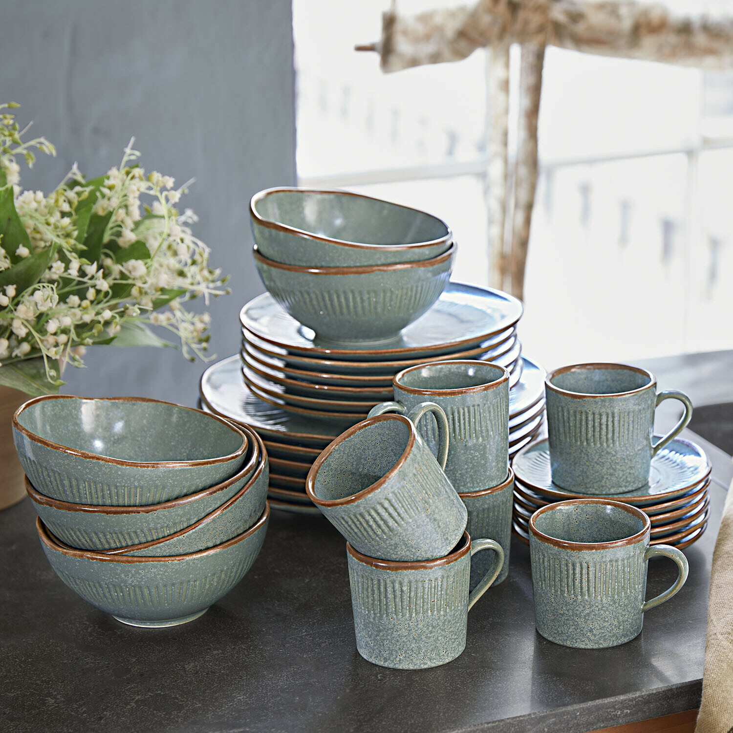 Groen keramisch servies met bruine rand op een zwarte tafel geplaatst