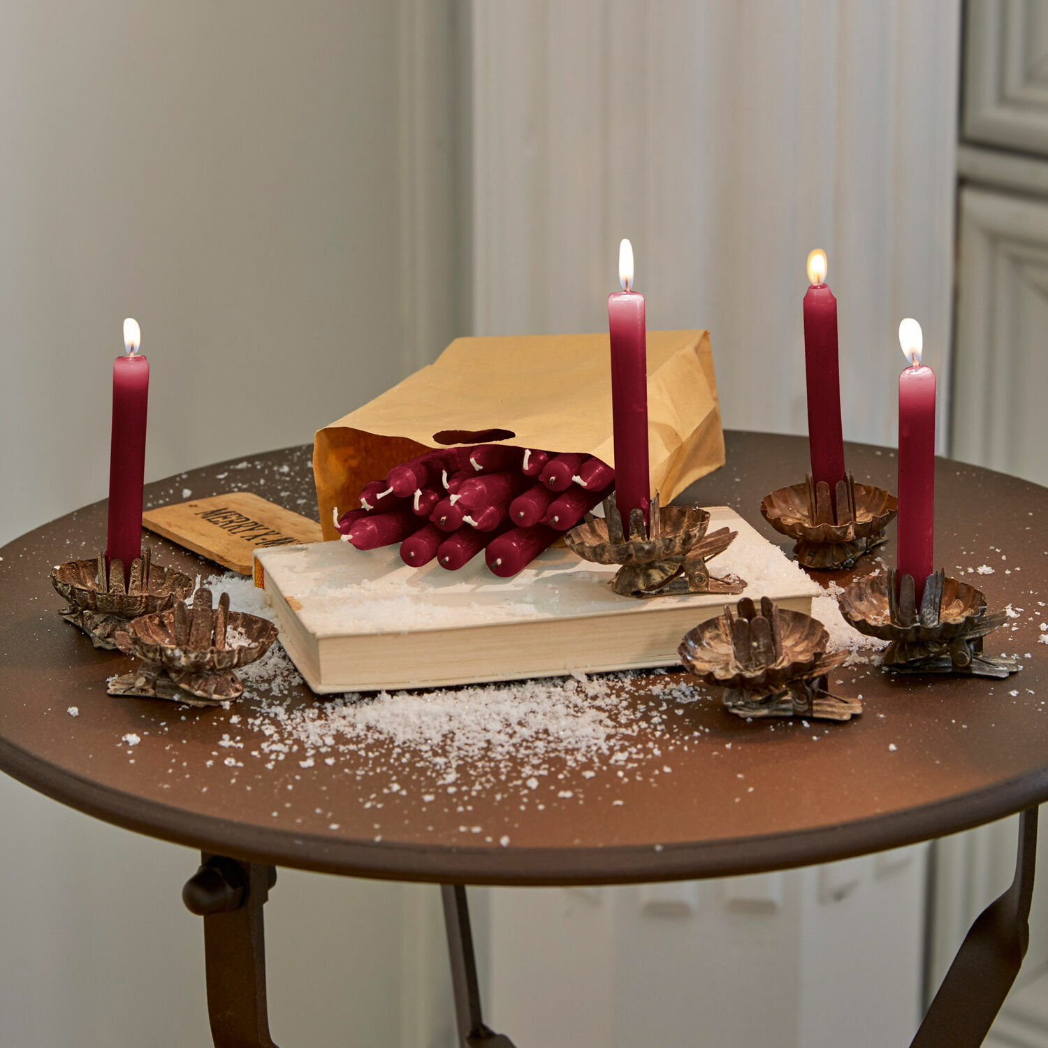 Kaars set van 20 Noufa Bordeauxrode kaarsen met klemmen op metalen tafel, papieren zak en nep sneeuw als kerstdecoratie