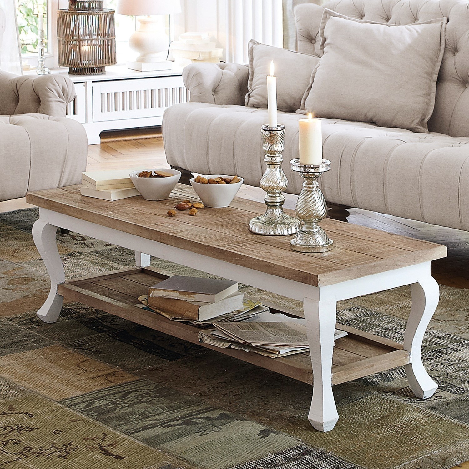 Houten salontafel met witte poten op tapijt, boeken en kaarsen, vintage sfeer