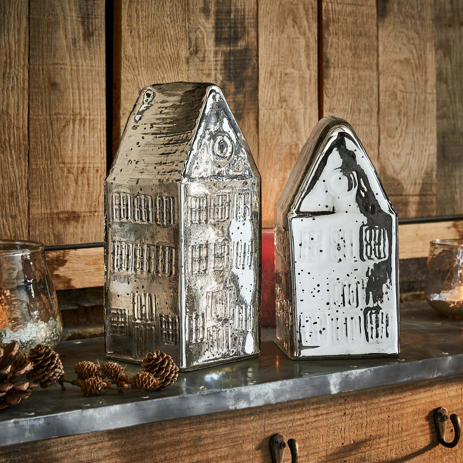 Decoratieve keramische huisjes in zilver en wit op houten achtergrond, interieurdecoratie