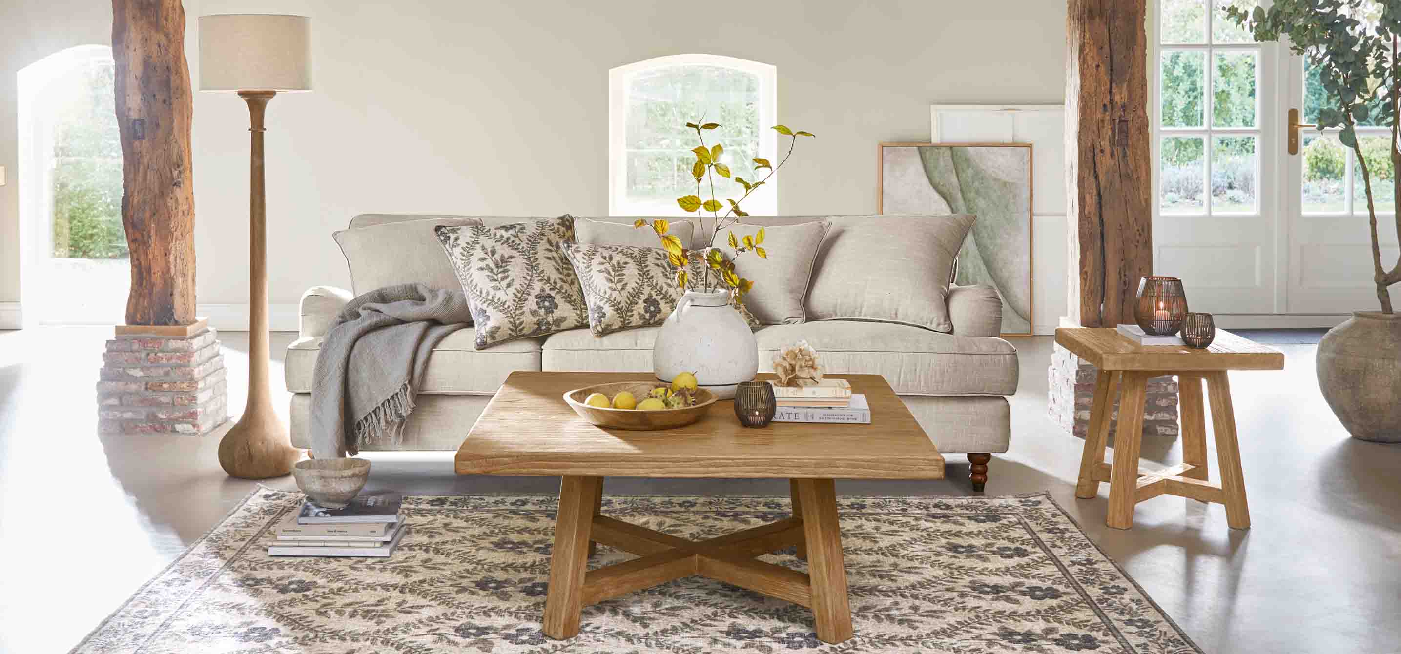 Gezellige woonkamer met beige bank, houten salontafel en natuurlijke decoraties