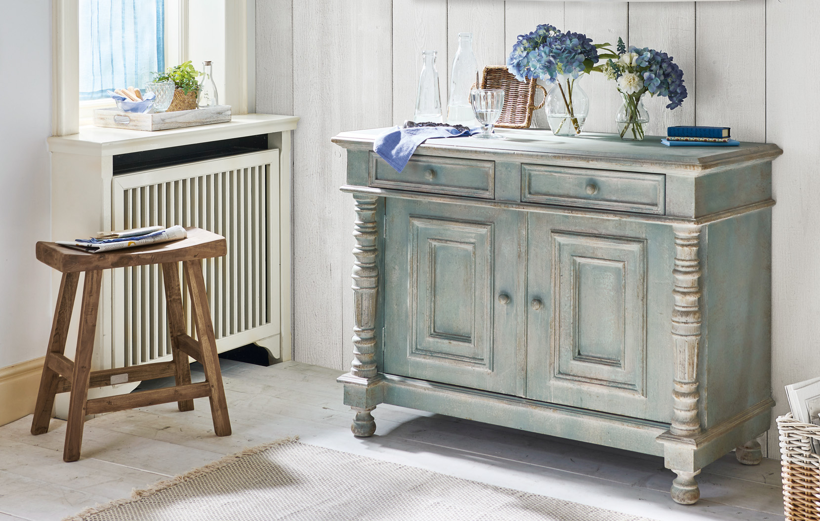 Shabby chic houten dressoir in groen-grijs met decoratieve bloemen en glazen flessen