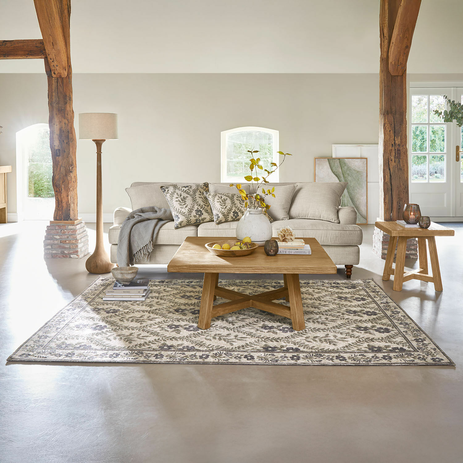 Vloerkleed Vellouris Gezellige woonkamer met beige bank, houten salontafel en vloerkleed met plantenpatroon
