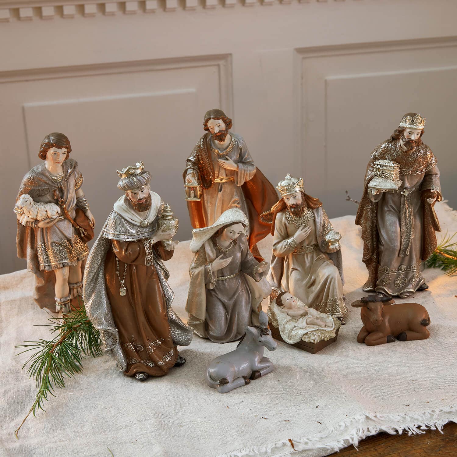 Set kerststalfiguren van hars in bruin-grijze tinten op een linnen doek voor kerstdecoratie