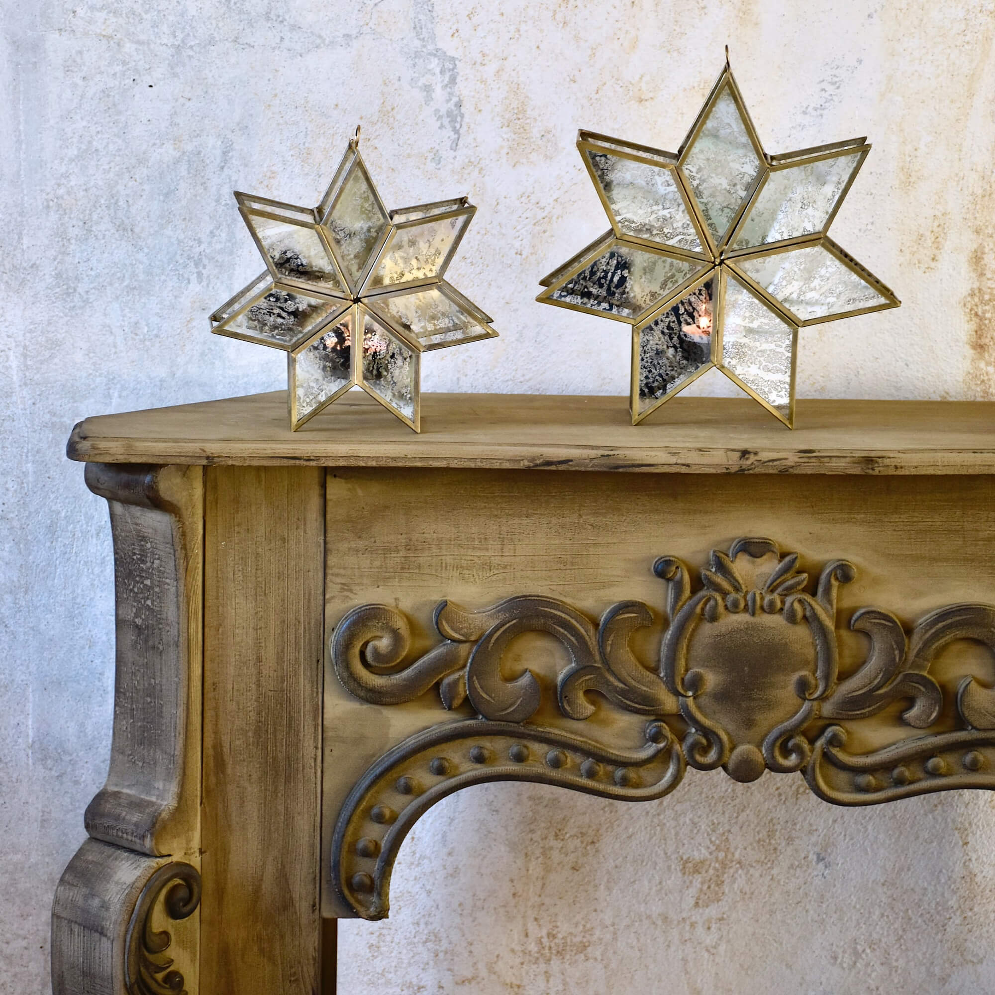 Houten schoorsteenconsole met gesneden vintage versieringen tegen een gestructureerde muur.