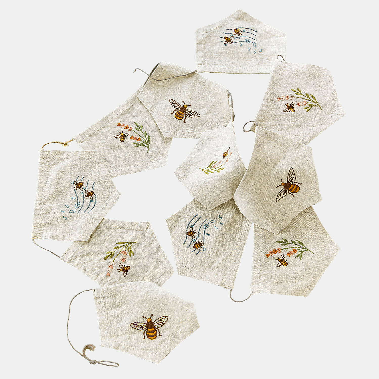 Linnen mondkapjes in lichte natuurtint met geborduurde bijen en bloemenmotieven, decoratieve set