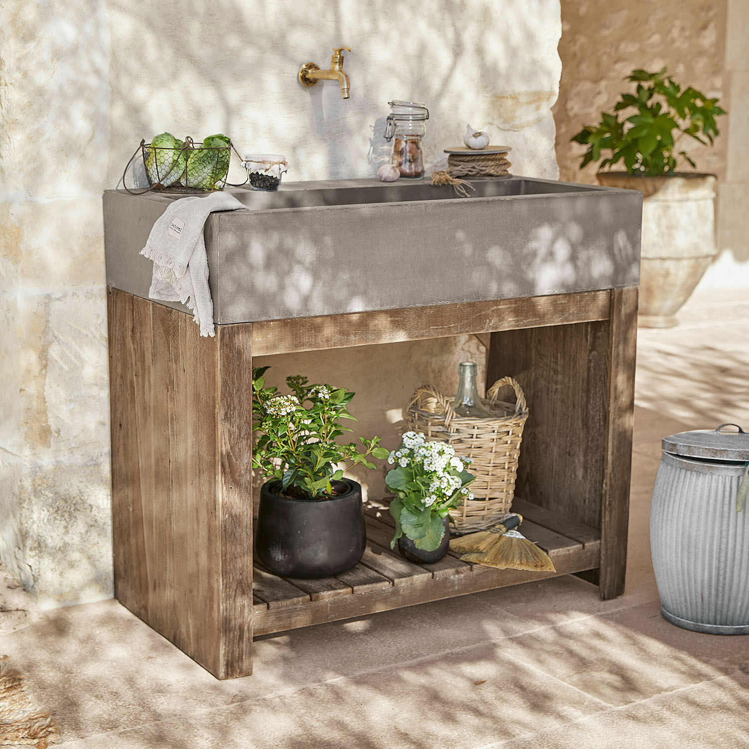 Gootsteenmeubel Baines Grijze betonnen wasbak op houten frame met planten en decoraties in zonnige tuin