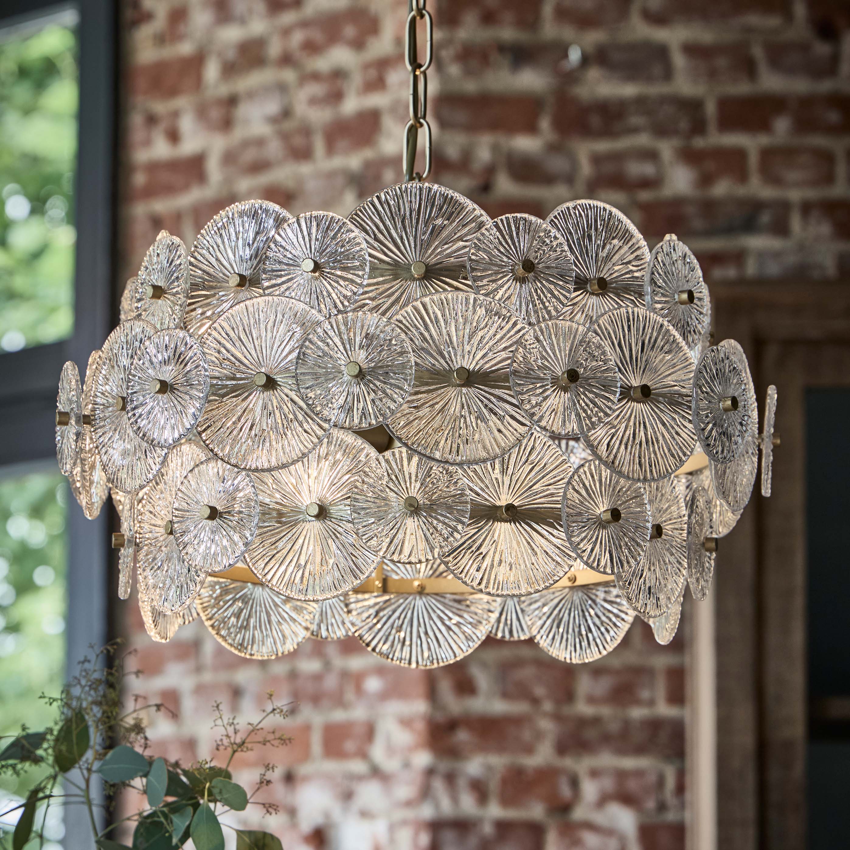Hanglamp van helder glas met ronde patronen en metalen elementen, decoratieve plafondlamp