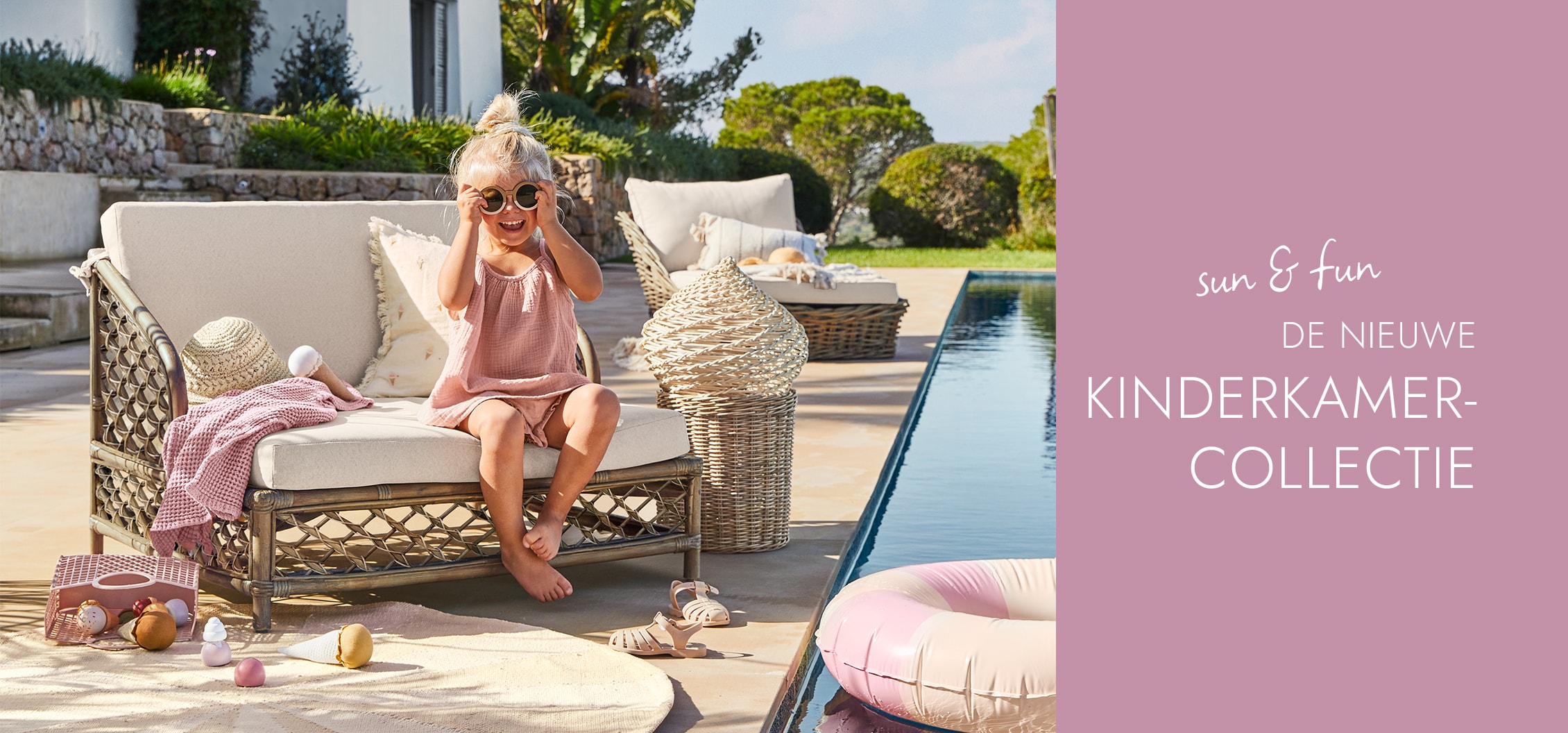 Kind in roze jurk zittend op beige rotanbank bij zwembad, nieuwe kinderkamercollectie