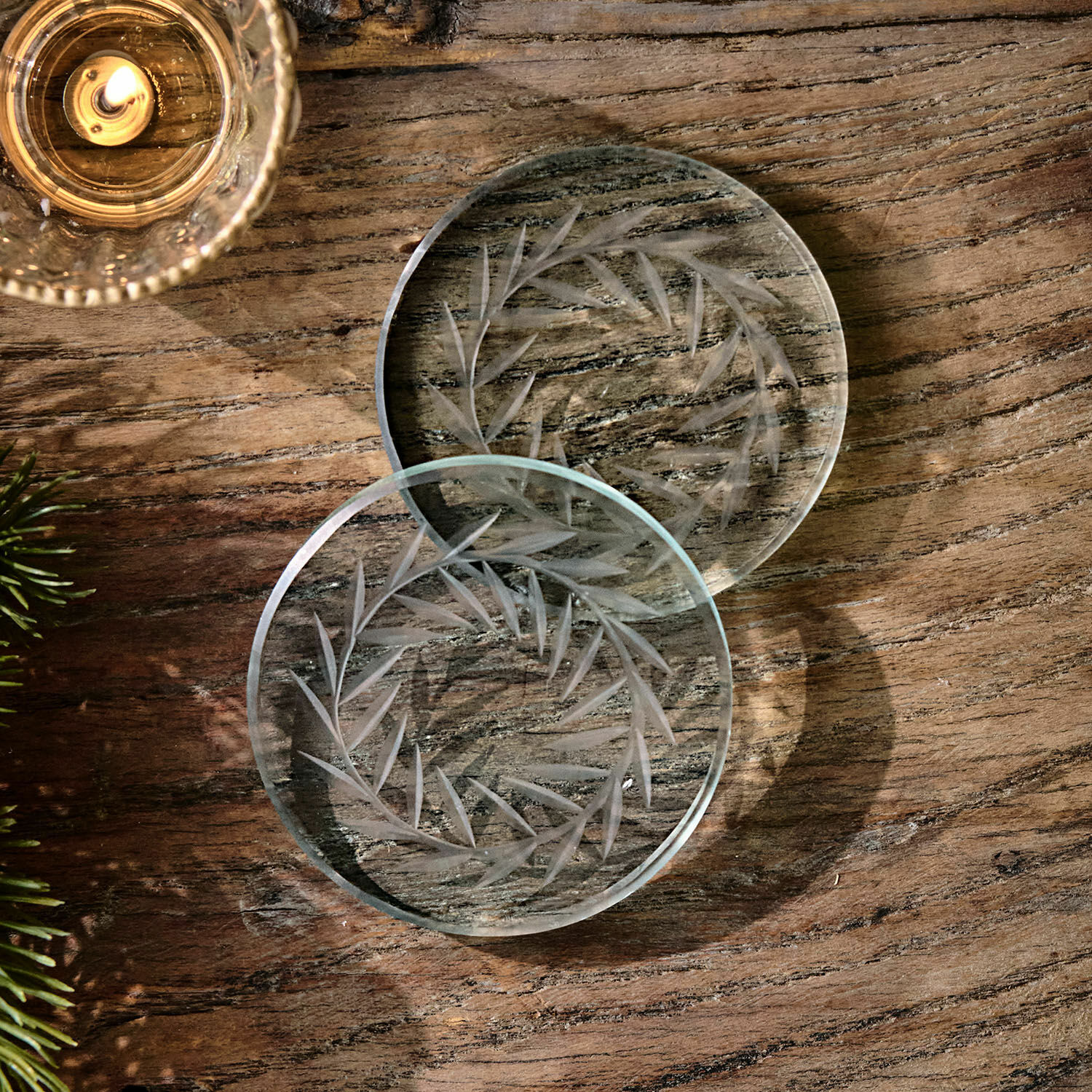 Onderzetter set van 2 Altheris Transparante glazen onderzetters met gegraveerd bladmotief op houten tafel, stijlvolle tafeldecoratie
