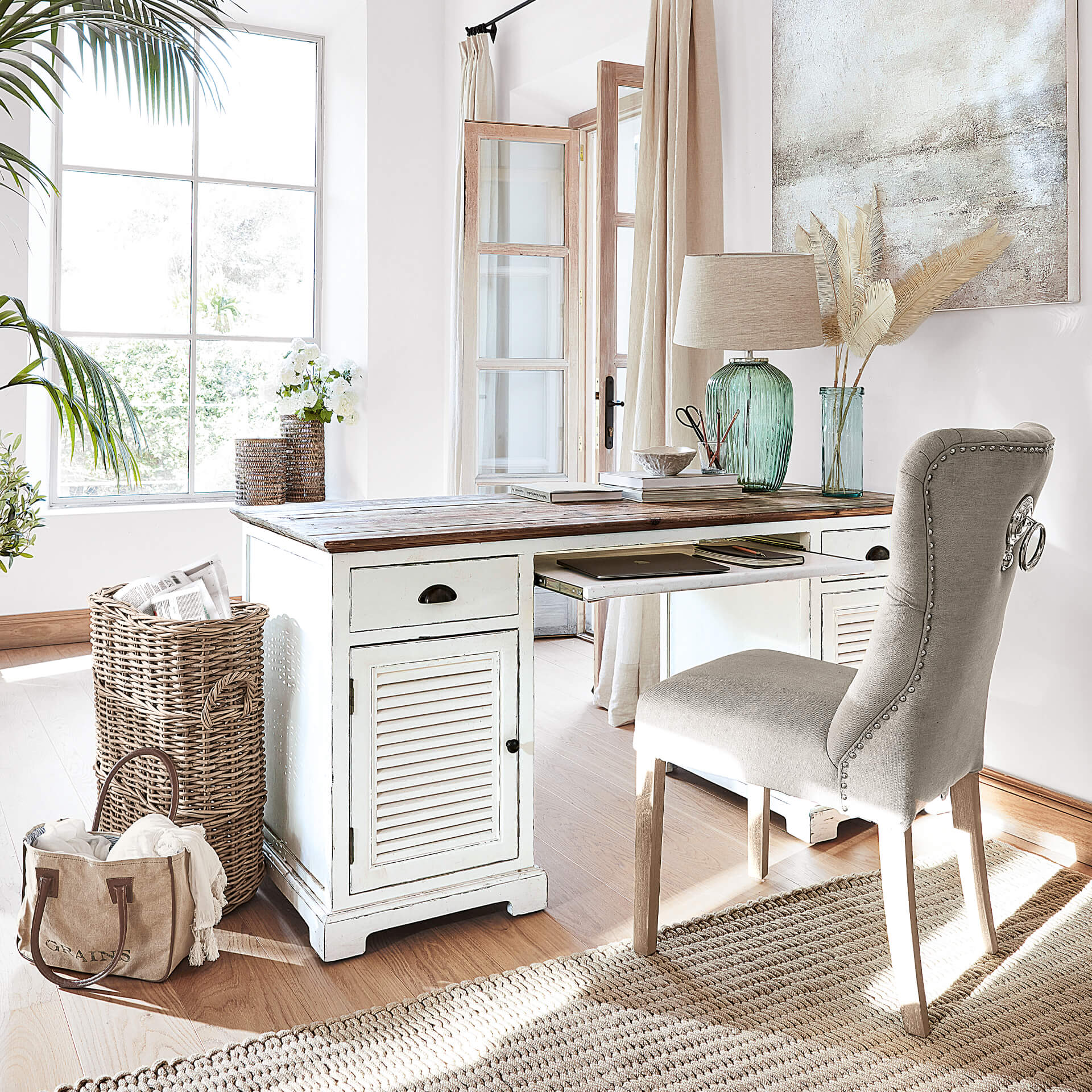Witte houten bureau met lades en grijze gestoffeerde stoel in lichte, gezellige kamer