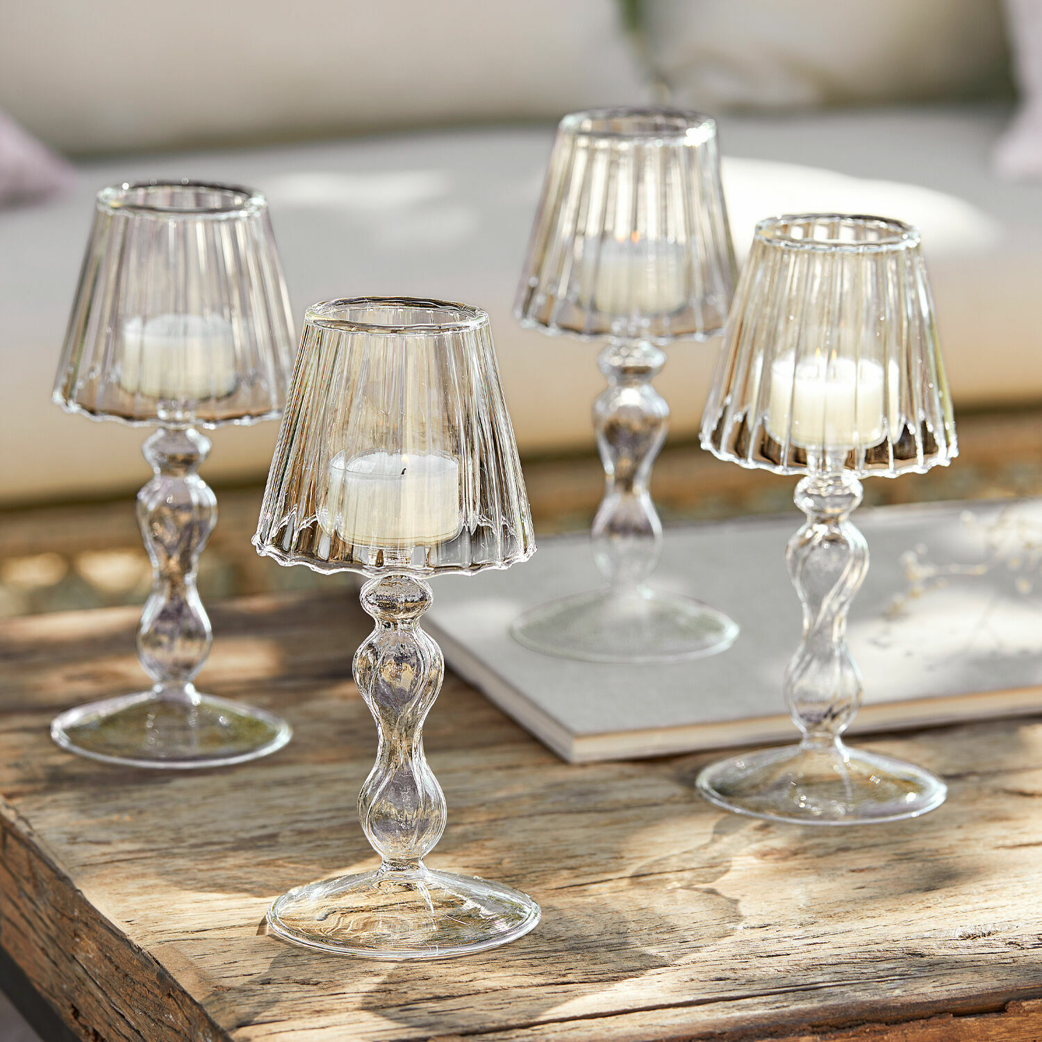 Glazen kandelaren met witte kaarsen op houten tafel, stijlvolle interieurdecoratie