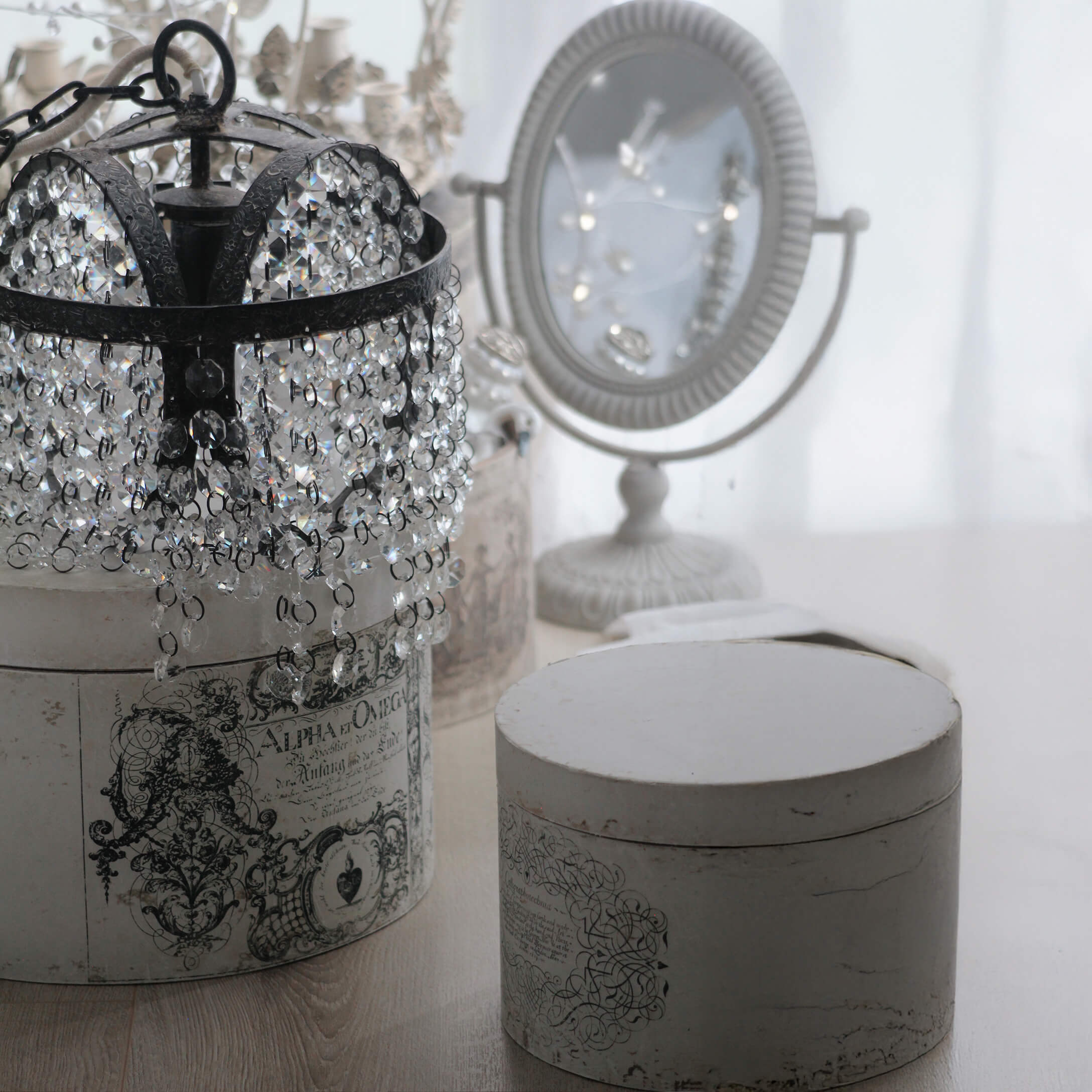 Kristallen kroonluchter met zwart metalen frame op witte vintage doos met ornamenten