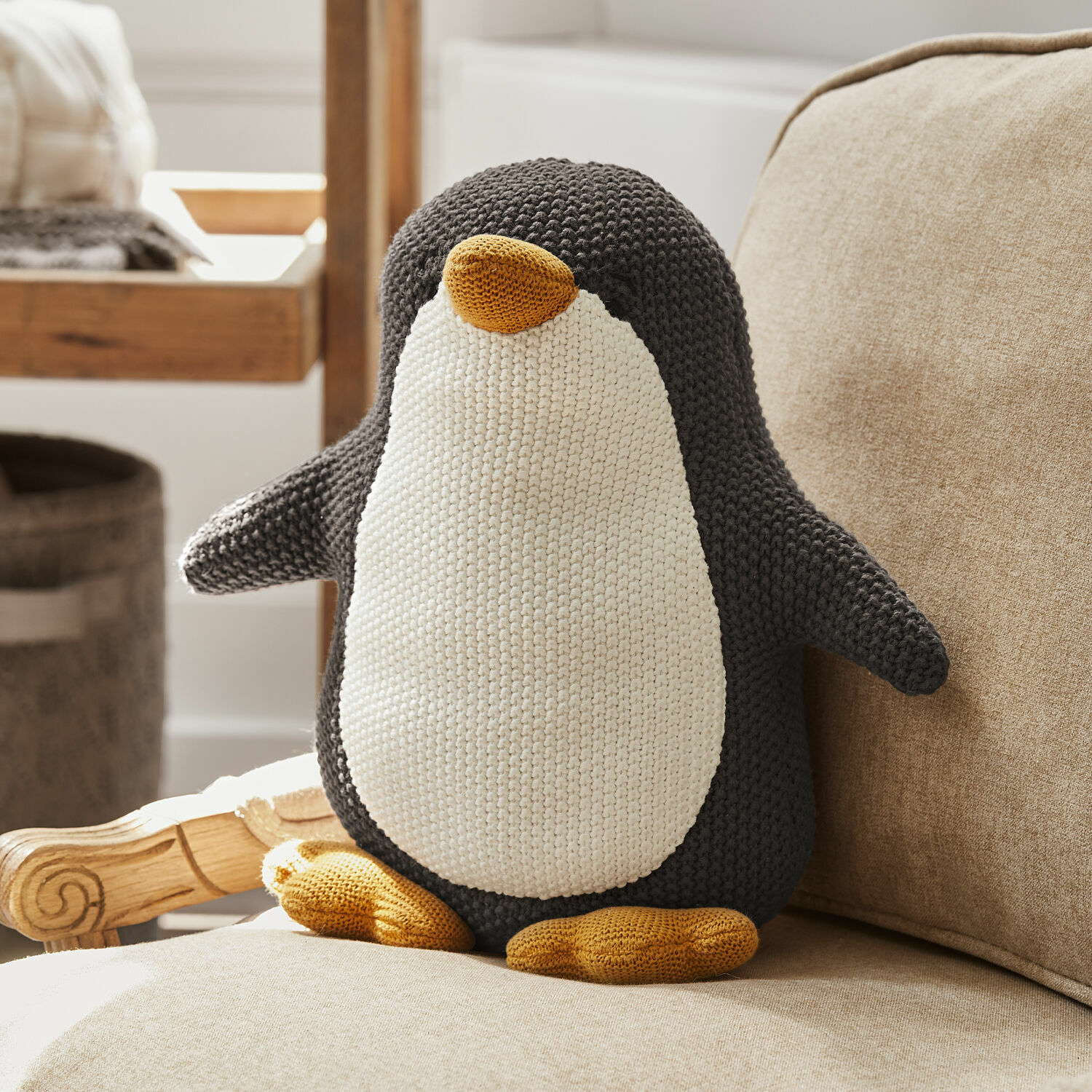 Zachte gebreide pinguïn kussen in grijs, wit en geel, decoratie voor de woonkamer