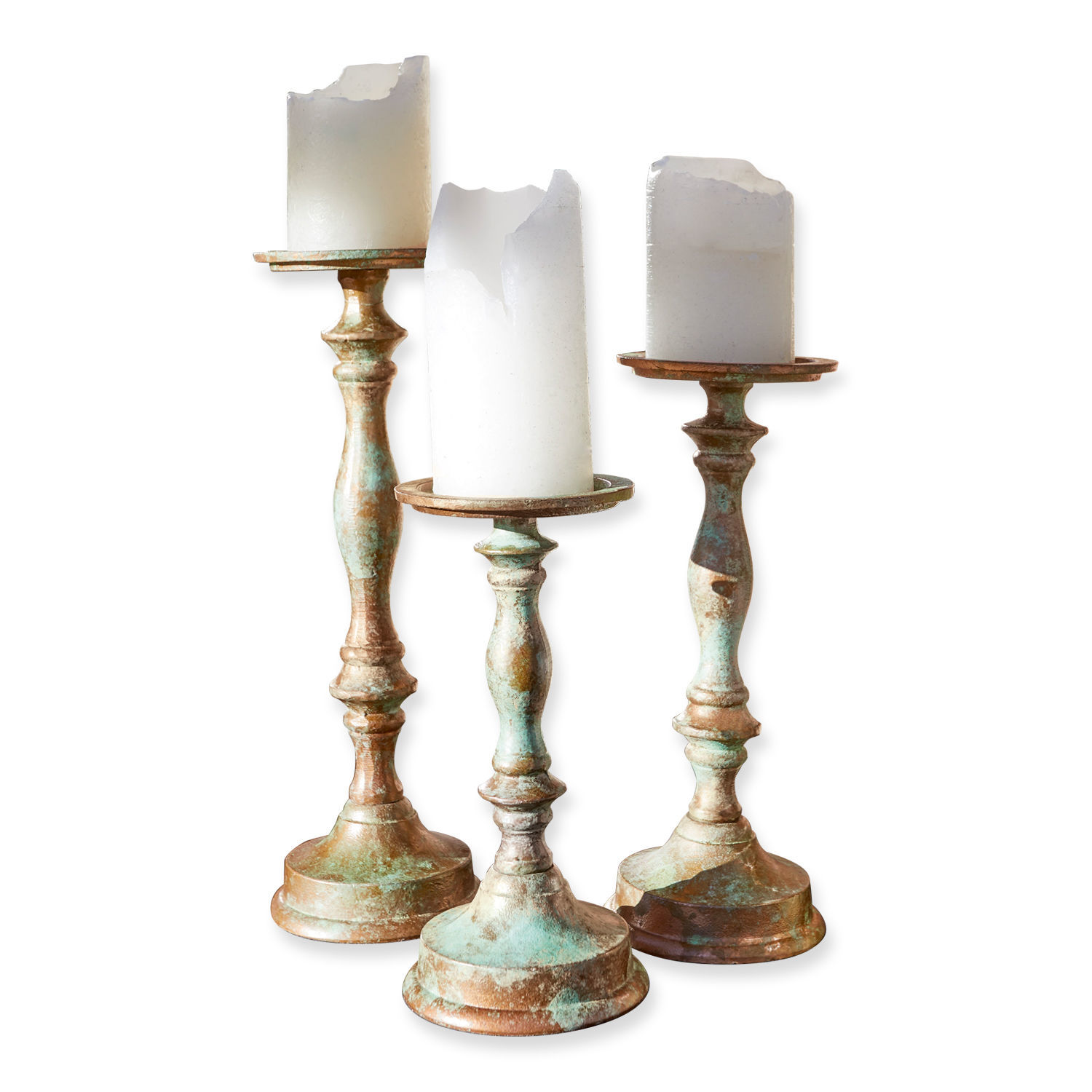 Set van drie metalen kandelaren met verweerde patina en witte decoratieve kaarsen
