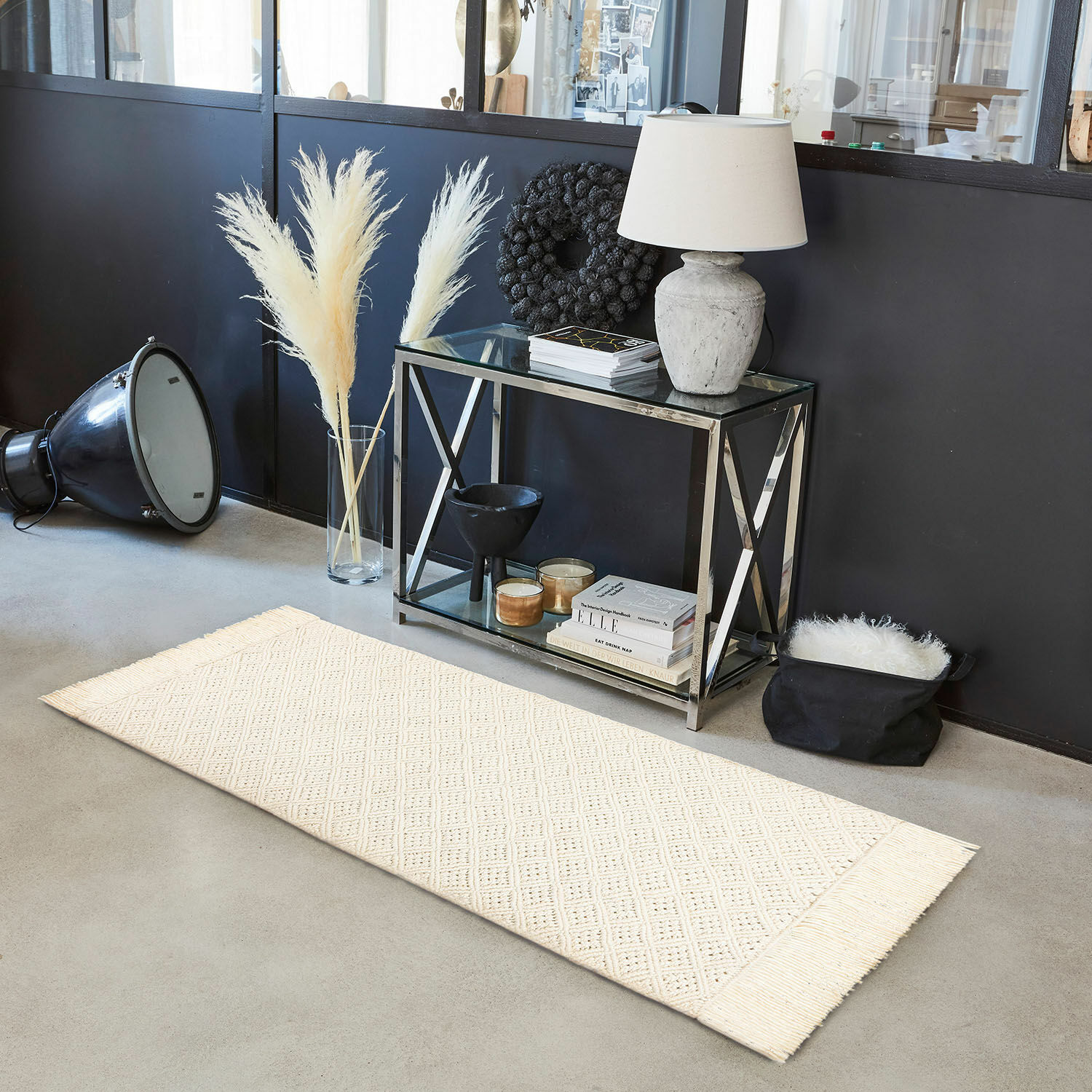 Crèmekleurig vloerkleed met franjes en geometrisch patroon op betonnen vloer in modern interieur